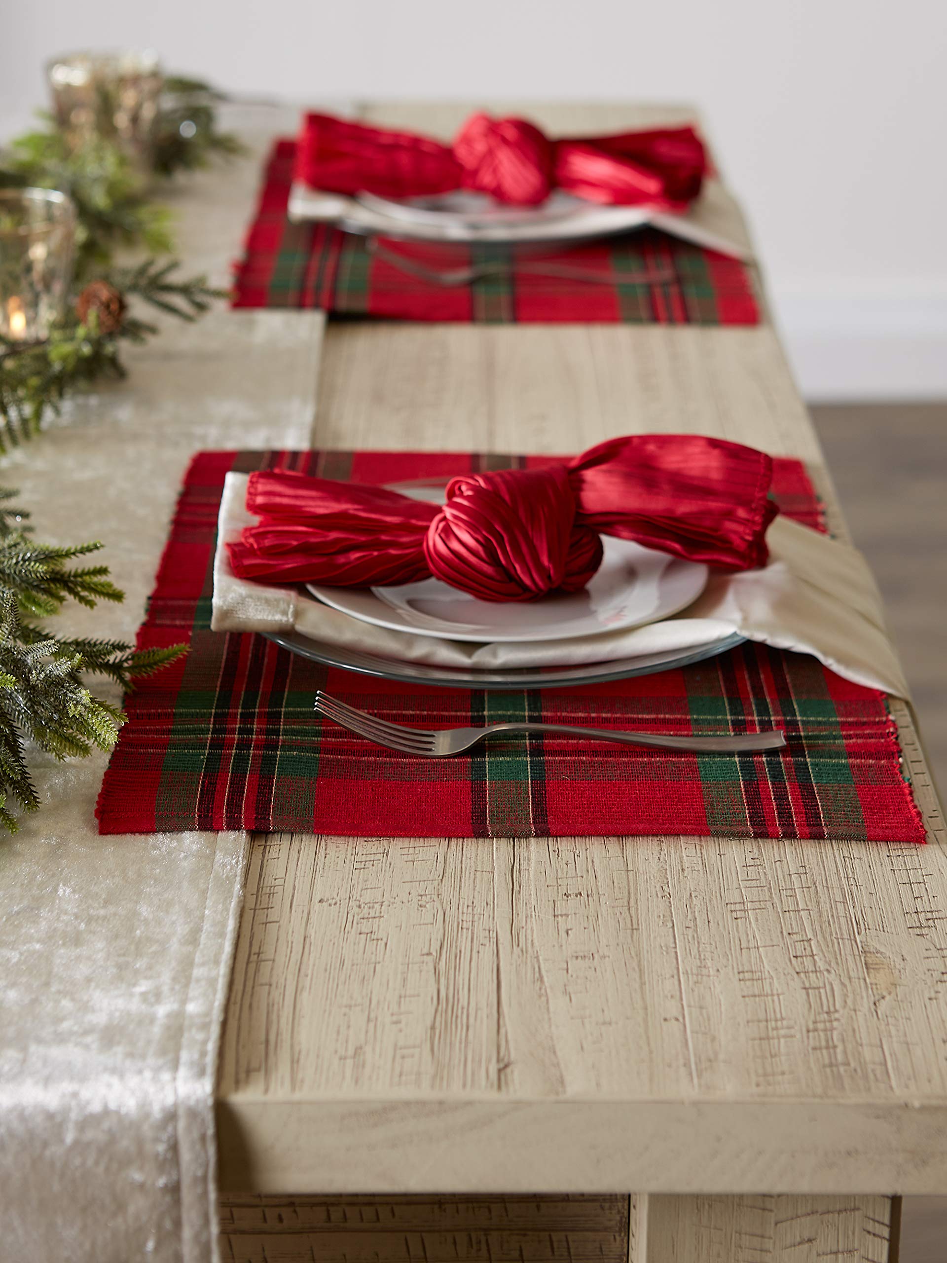 Side view of a wood table with separate plaid place settings and red napkins