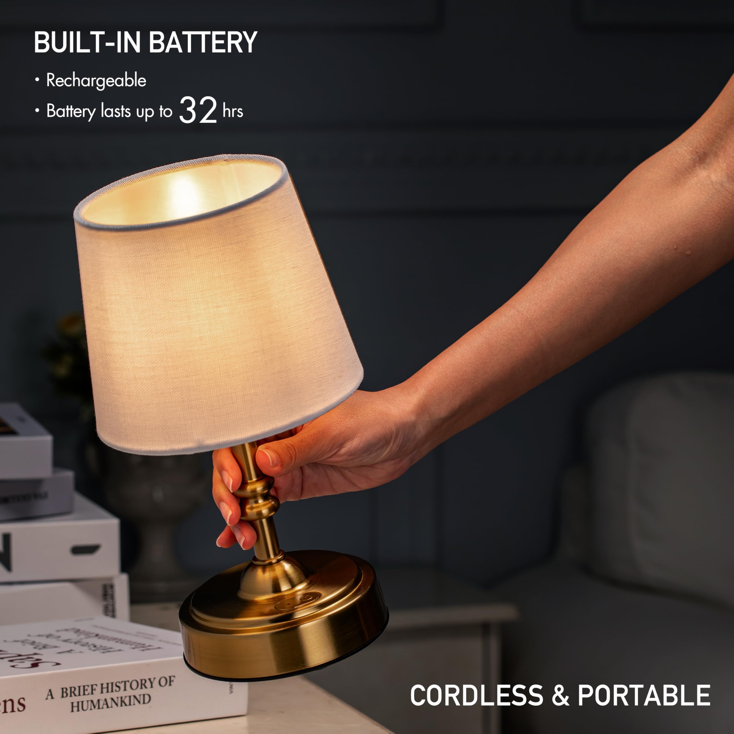A hand holding the illuminated O’Bright Seraph Mini table lamp