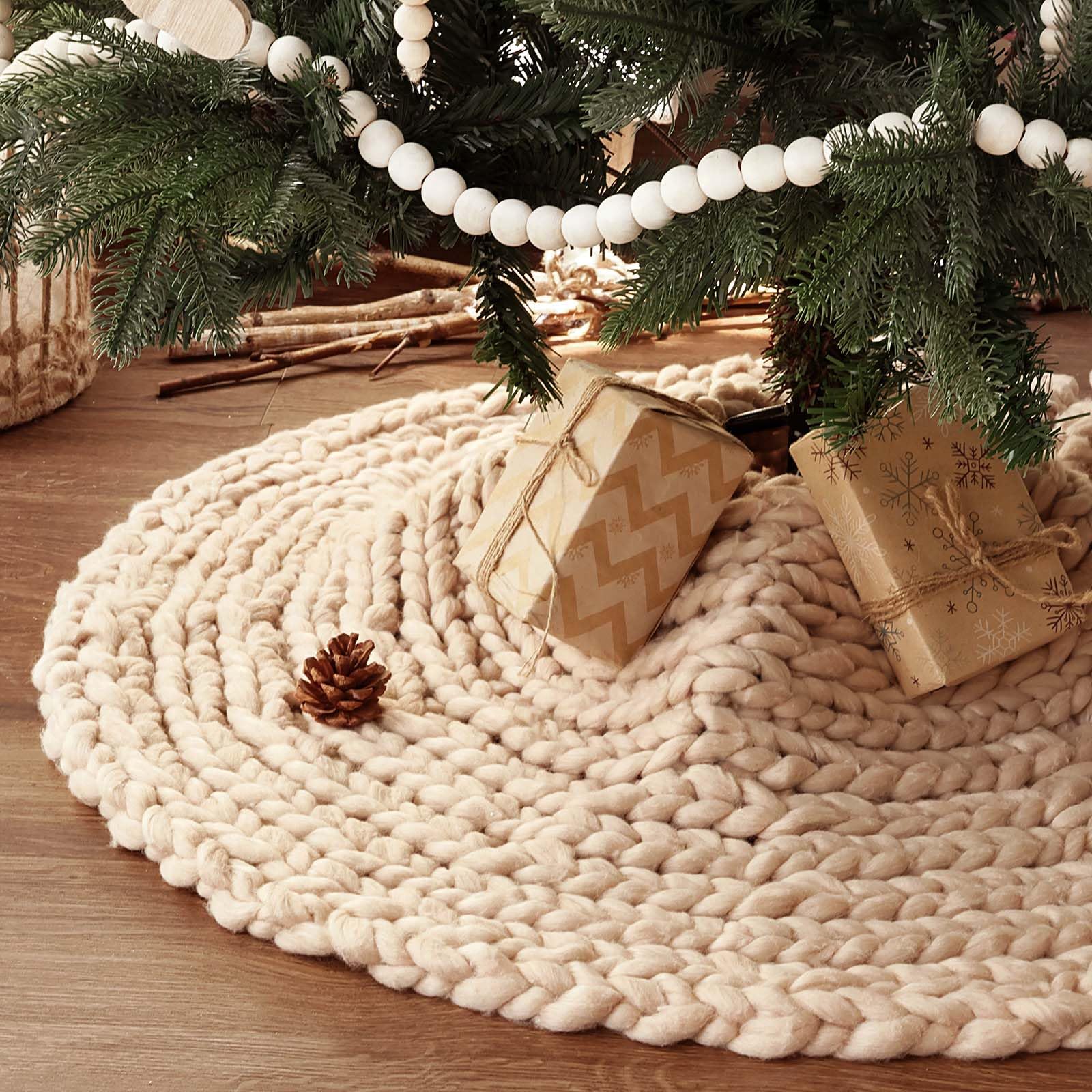 Beige LimBridge knitted skirt around a tree base with separate wrapped gifts
