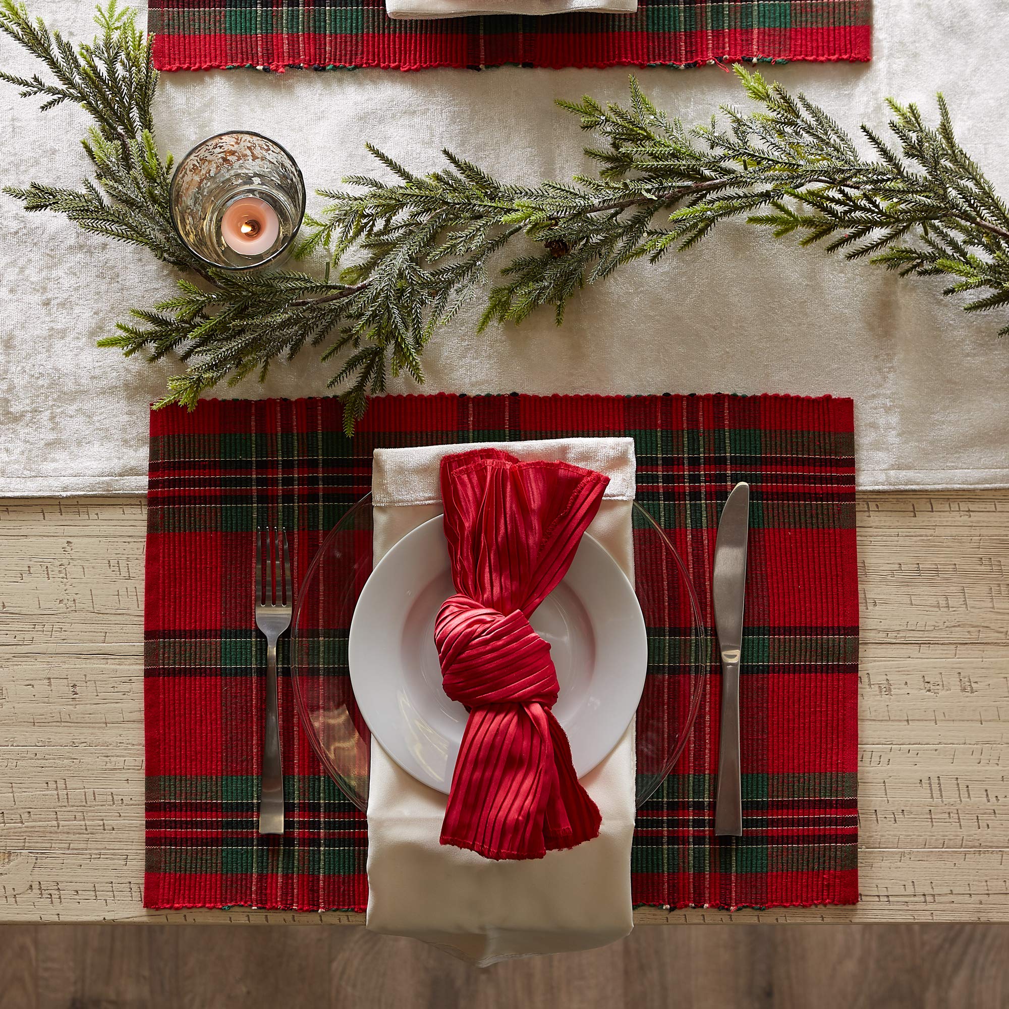 Single DII plaid setting beneath white plates and a red cloth napkin