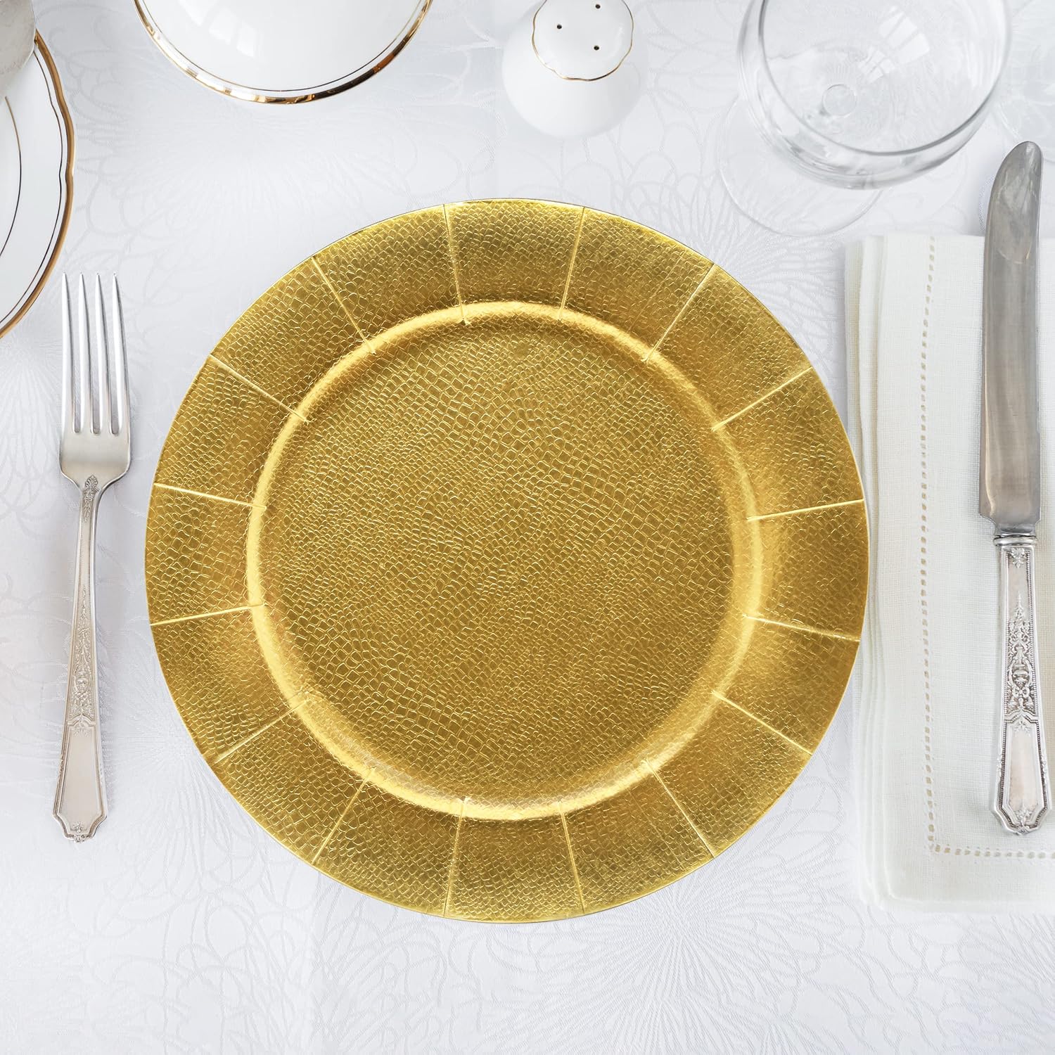 Gold charger perimeter beneath a white place setting