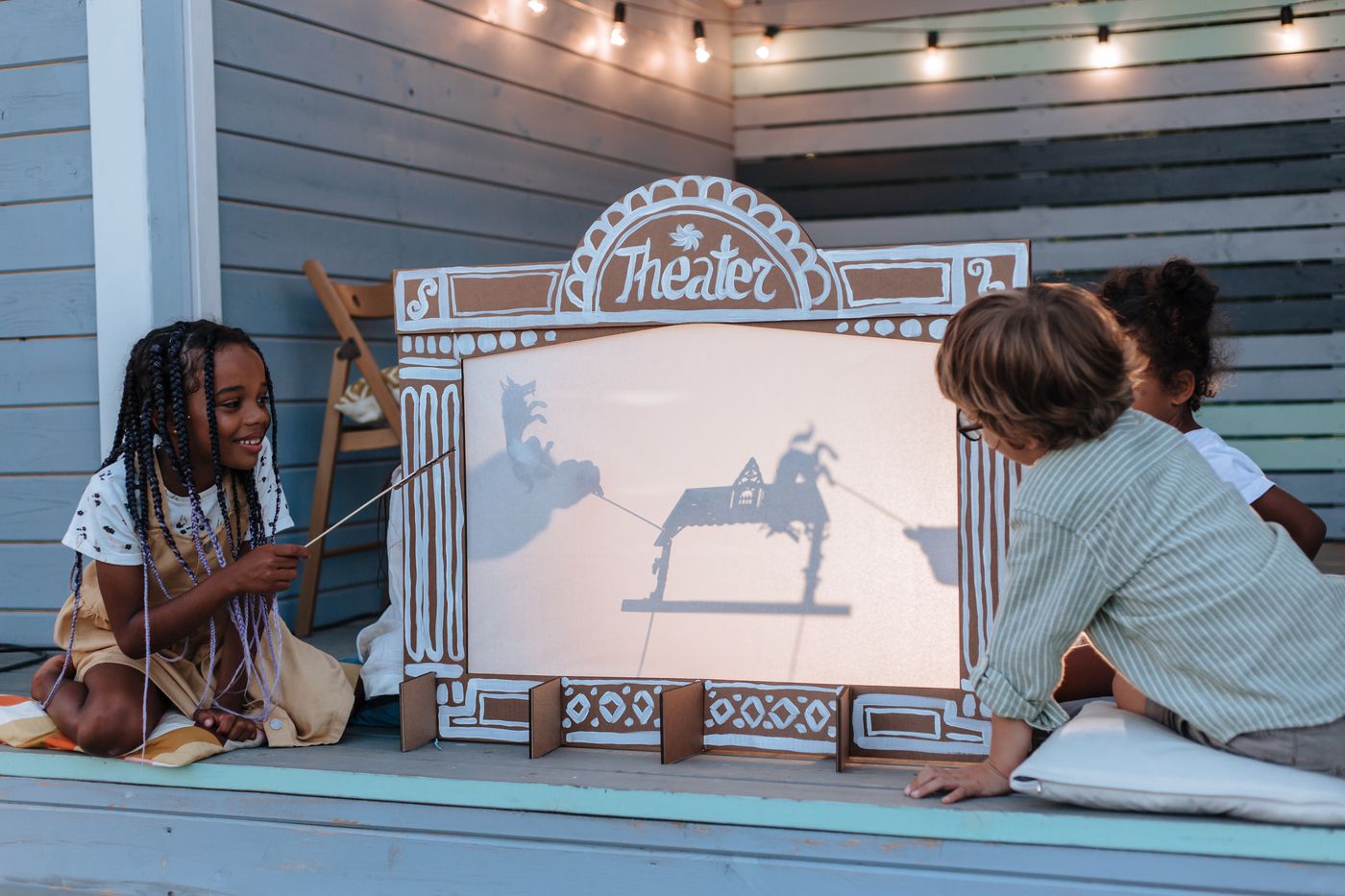 Two children sharing a shadow-puppet theater