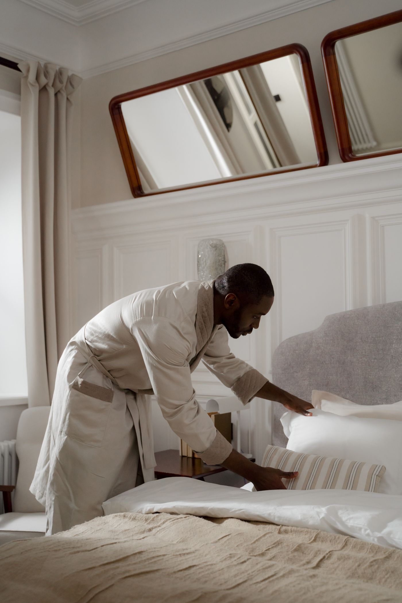 Person smoothing bedding beside a mattress