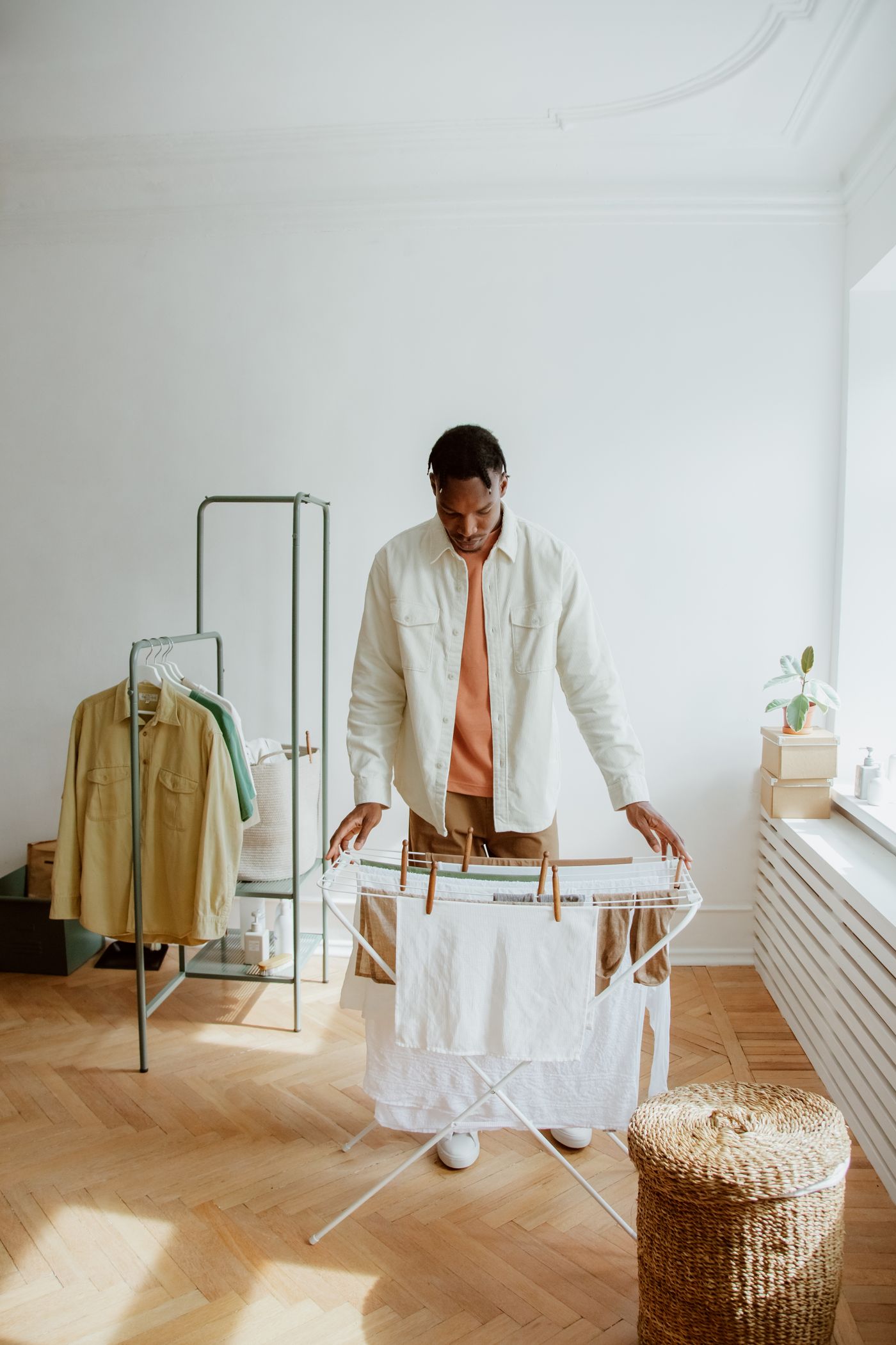 A person placing laundry on a folding rack