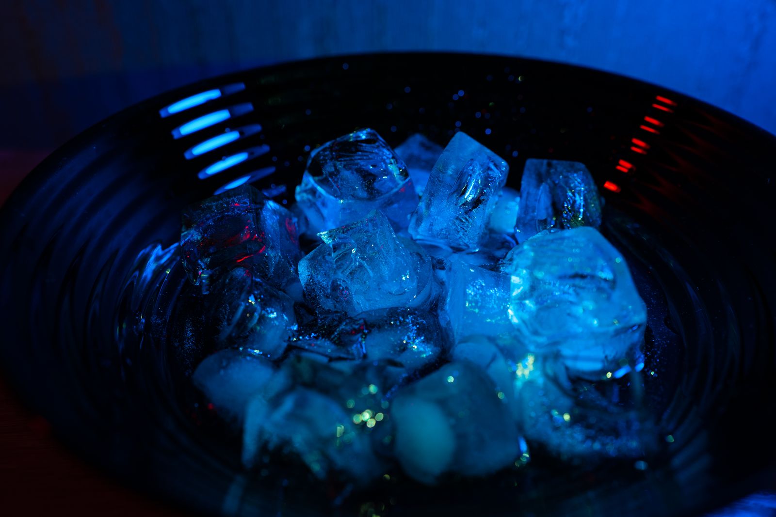 Ice cubes in a bowl illuminated by blue light