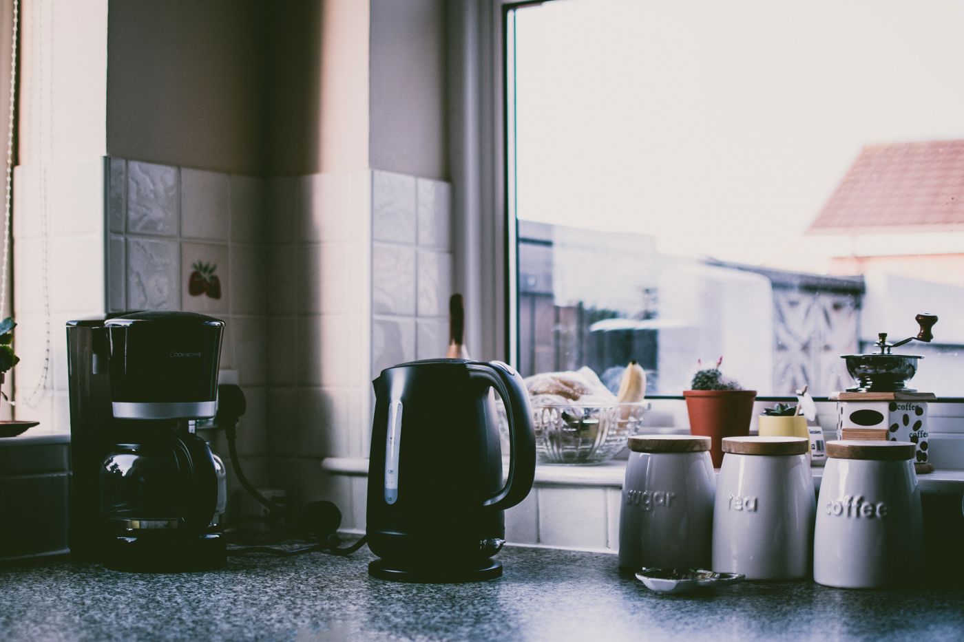 A filter coffee maker and kettle sharing a kitchen counter