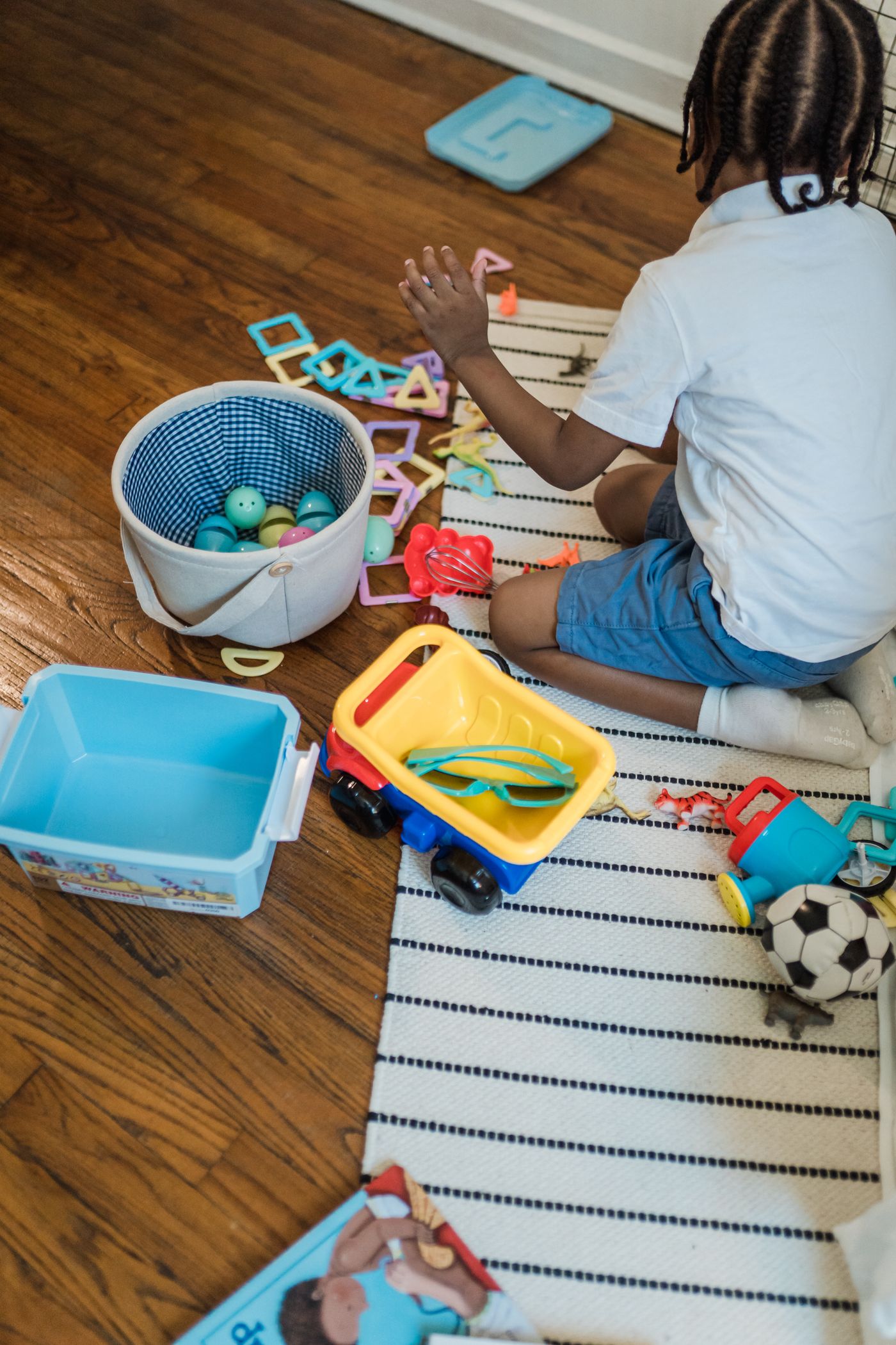 Child selecting familiar objects from a small play area