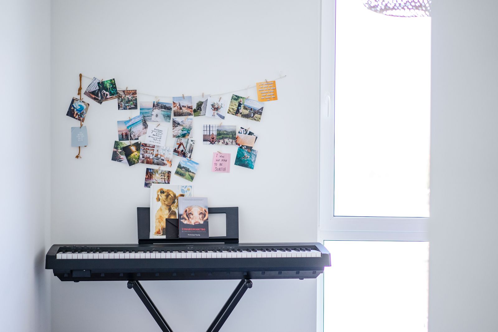 A keyboard on a stand beneath photographs on a wall