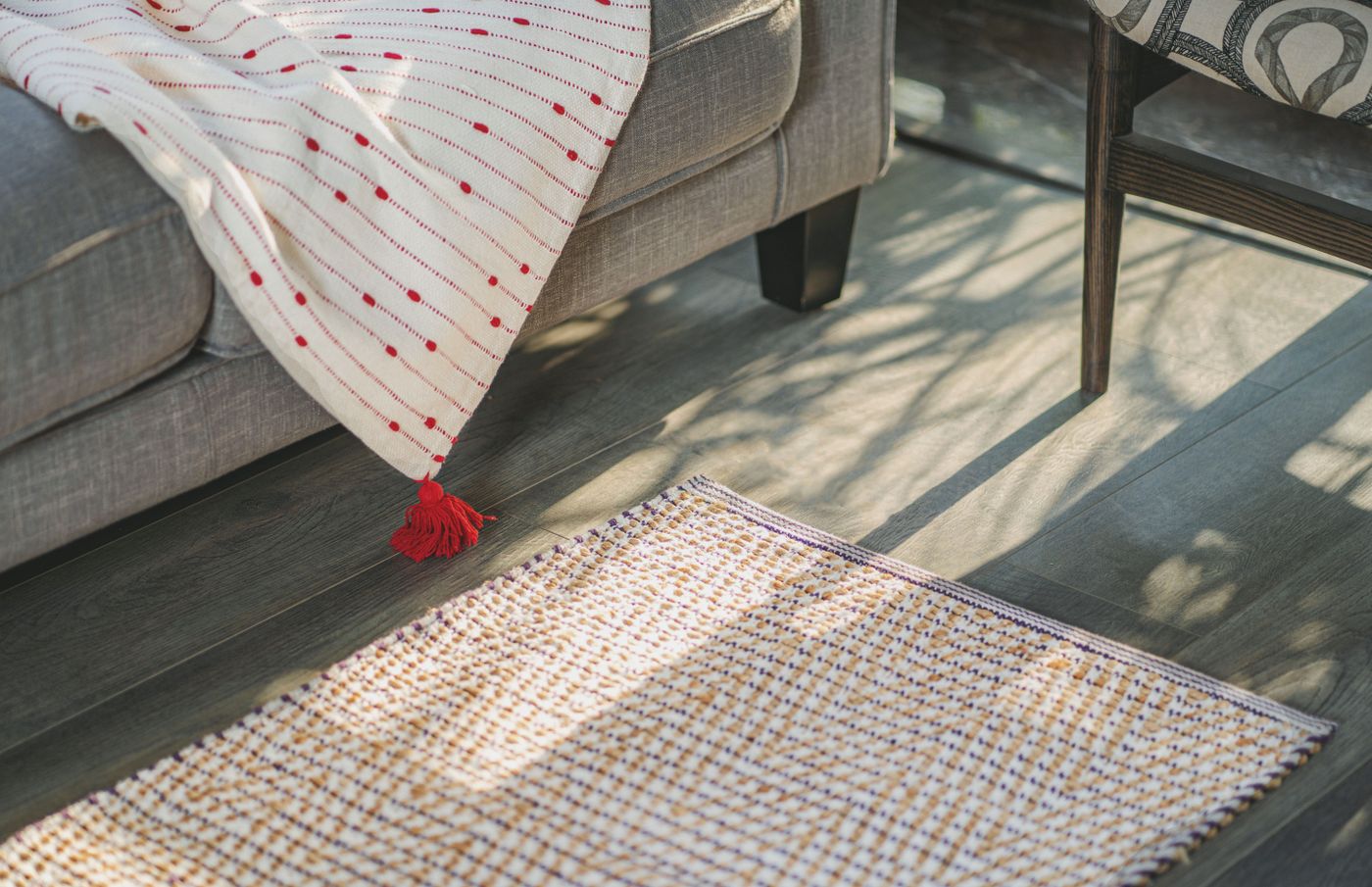 Textured rug beside a sofa with a patterned throw