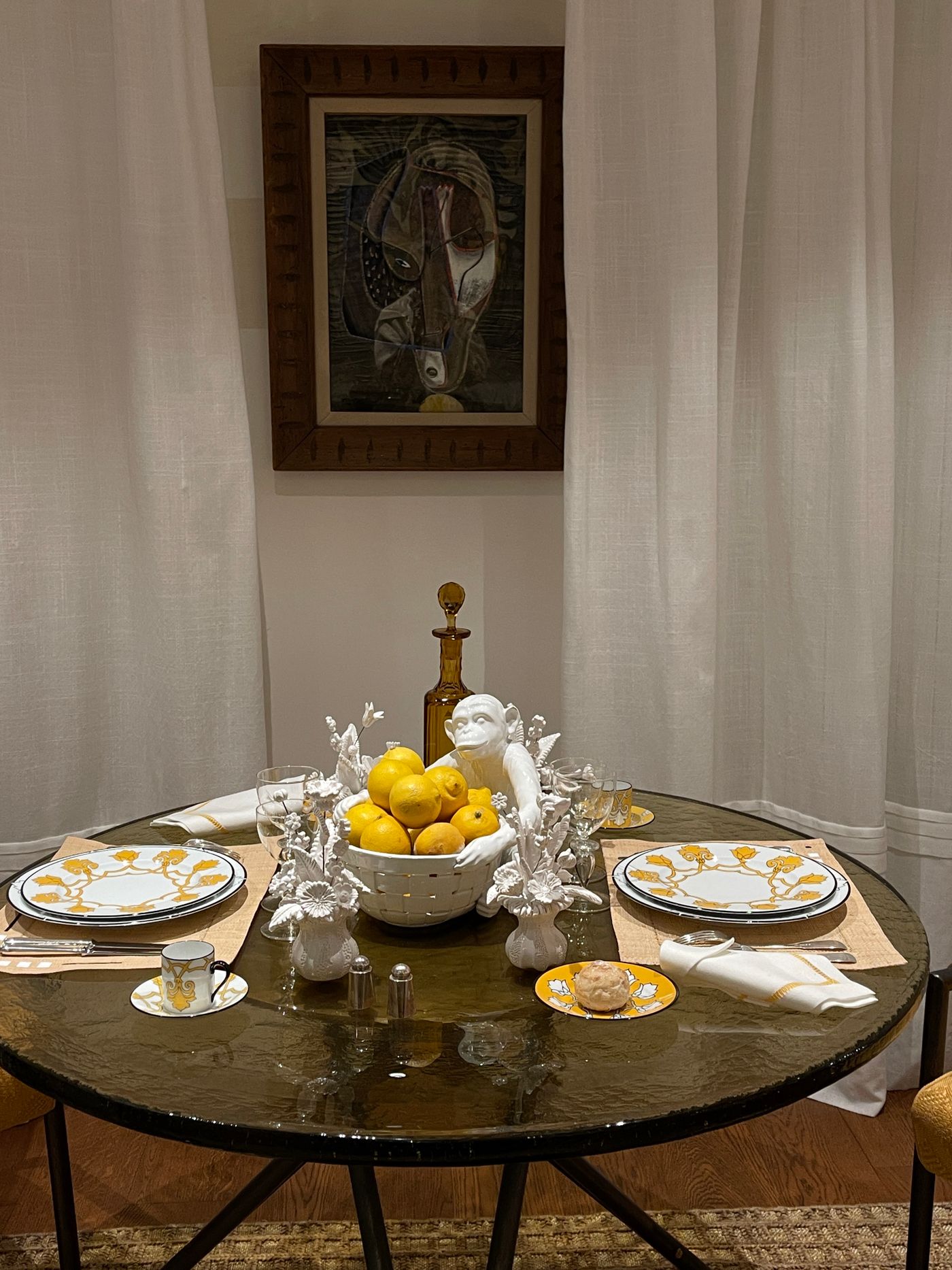 A small round dining table set with plates and cups