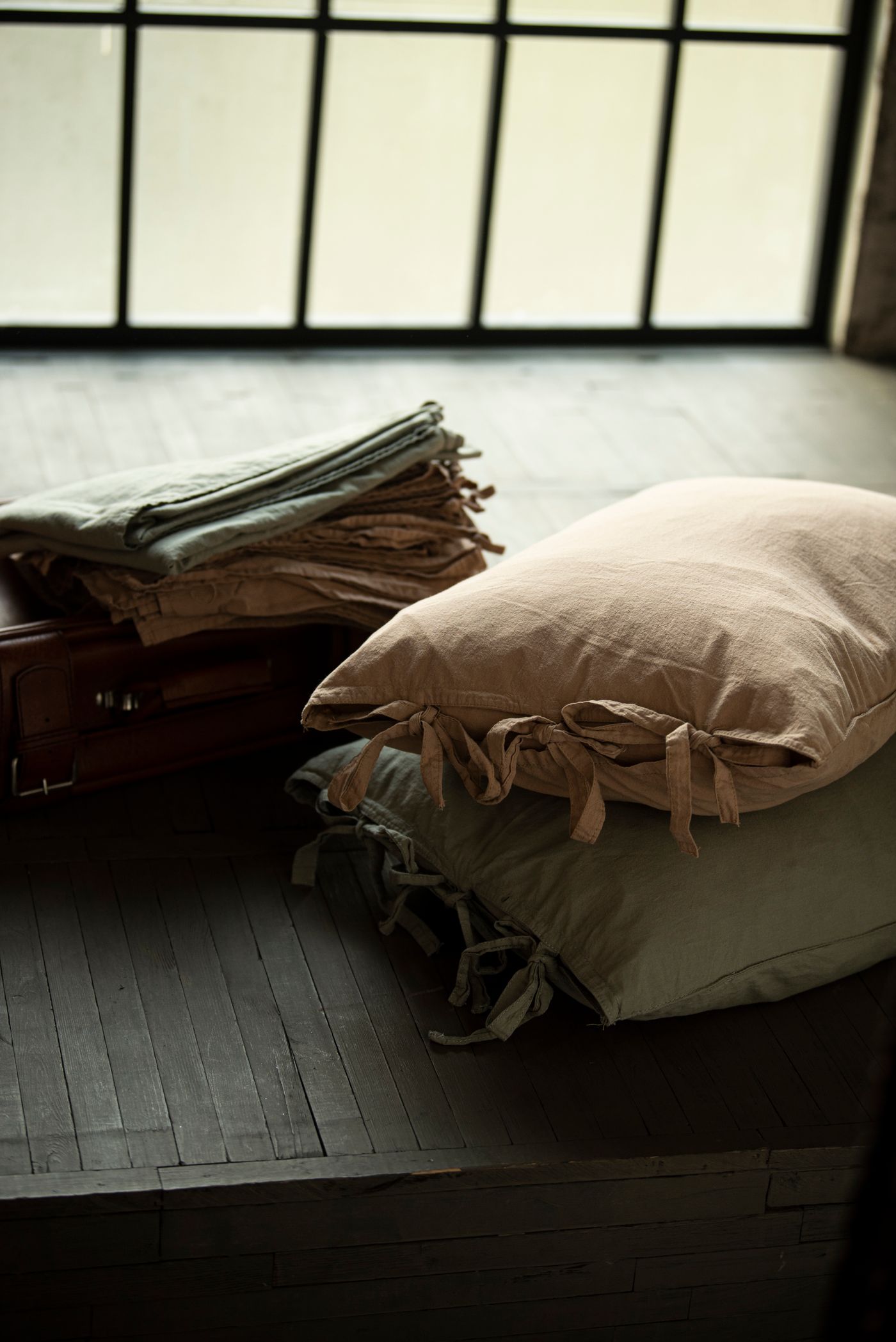 A pair of floor cushions near a window