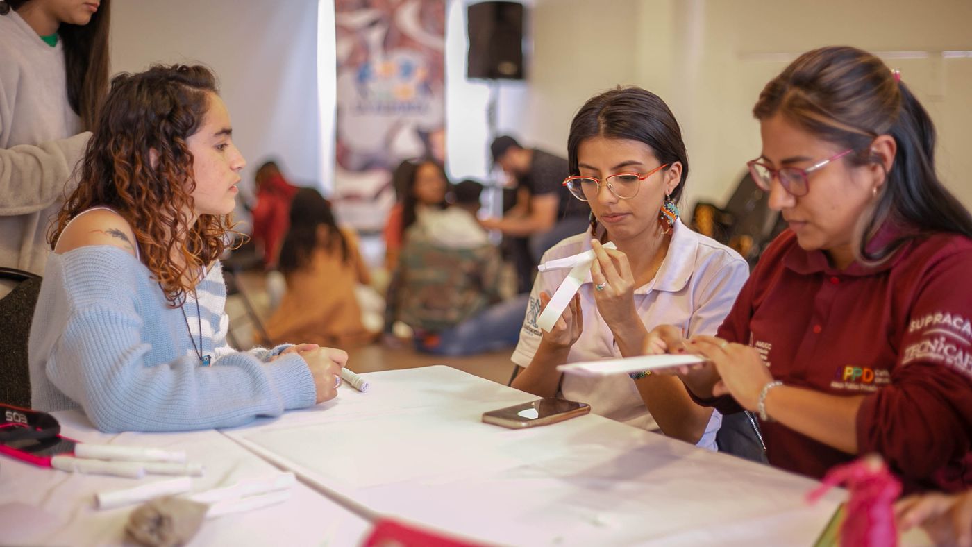 People working on folded-paper crafts at a shared table