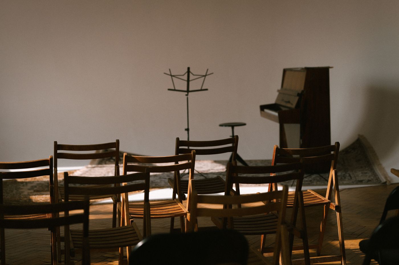 Chairs arranged in a music room with stands and a piano