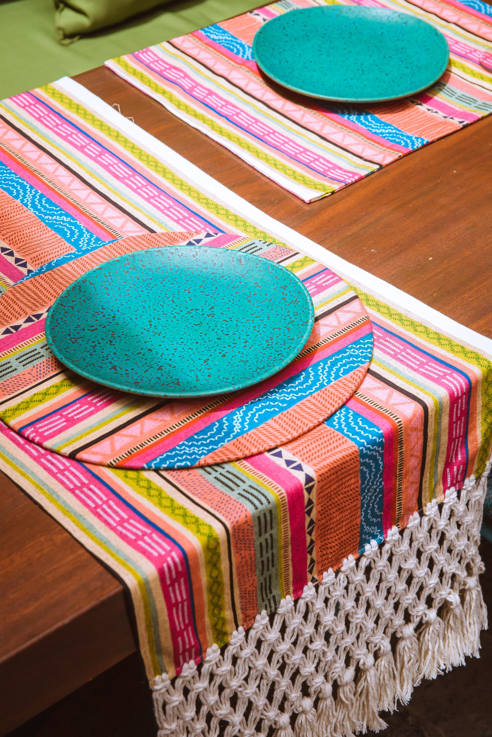 Colorful table runners beneath plates on a wooden table
