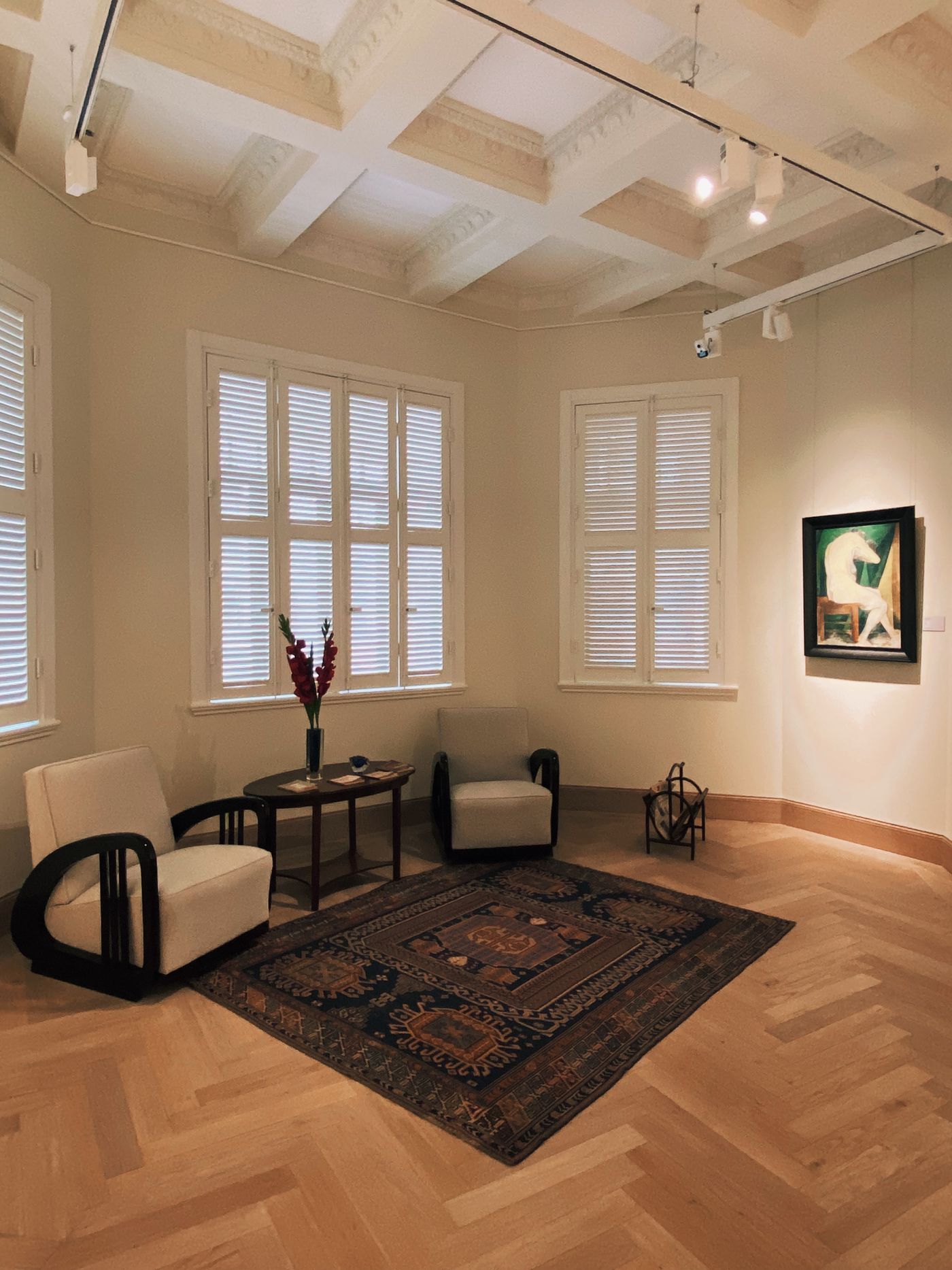 Two chairs and a small table arranged beside a rug