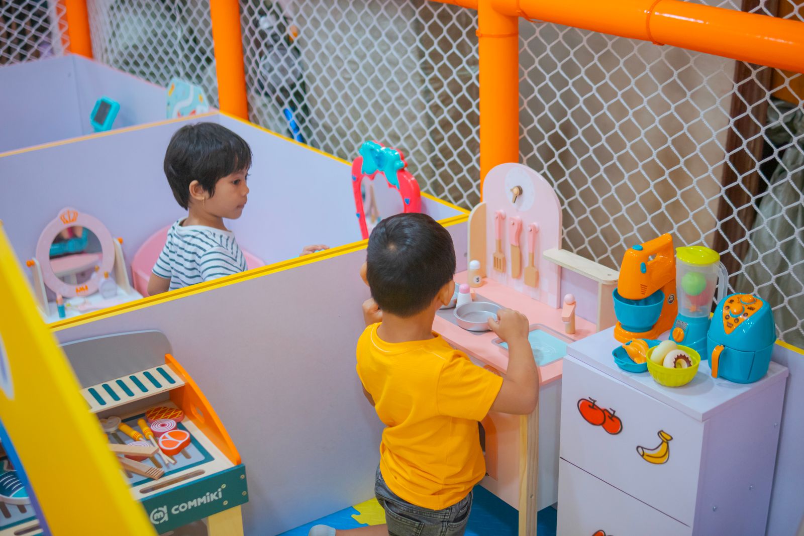 Children playing in a pretend kitchen area