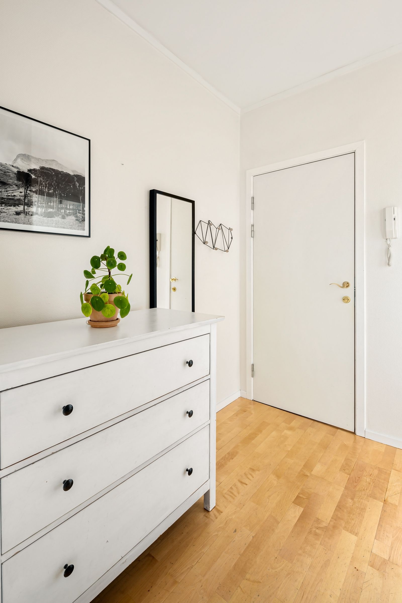 A white dresser near a bedroom doorway
