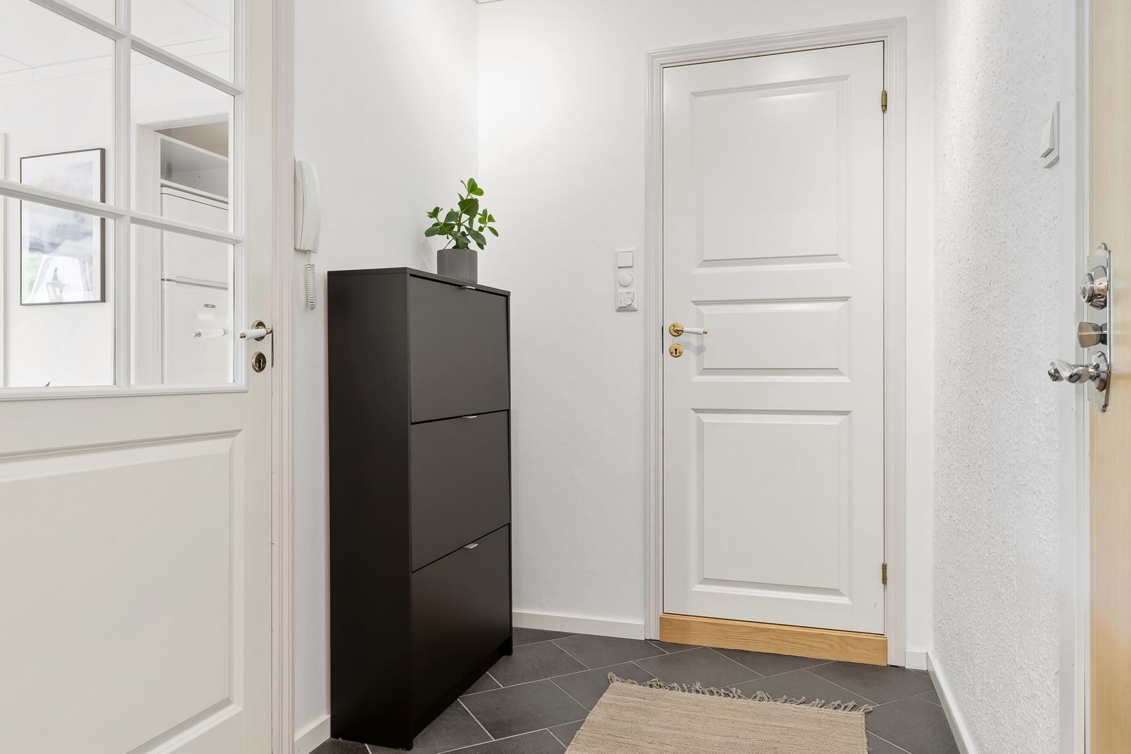 A dark dresser near two white interior doors