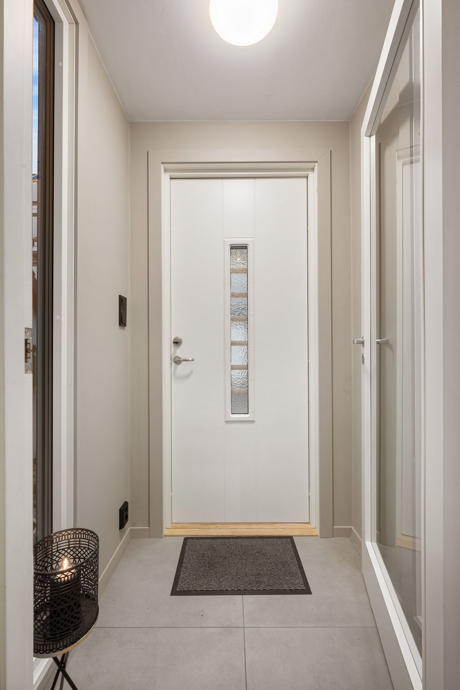 White door with glass insert in a bright house corridor