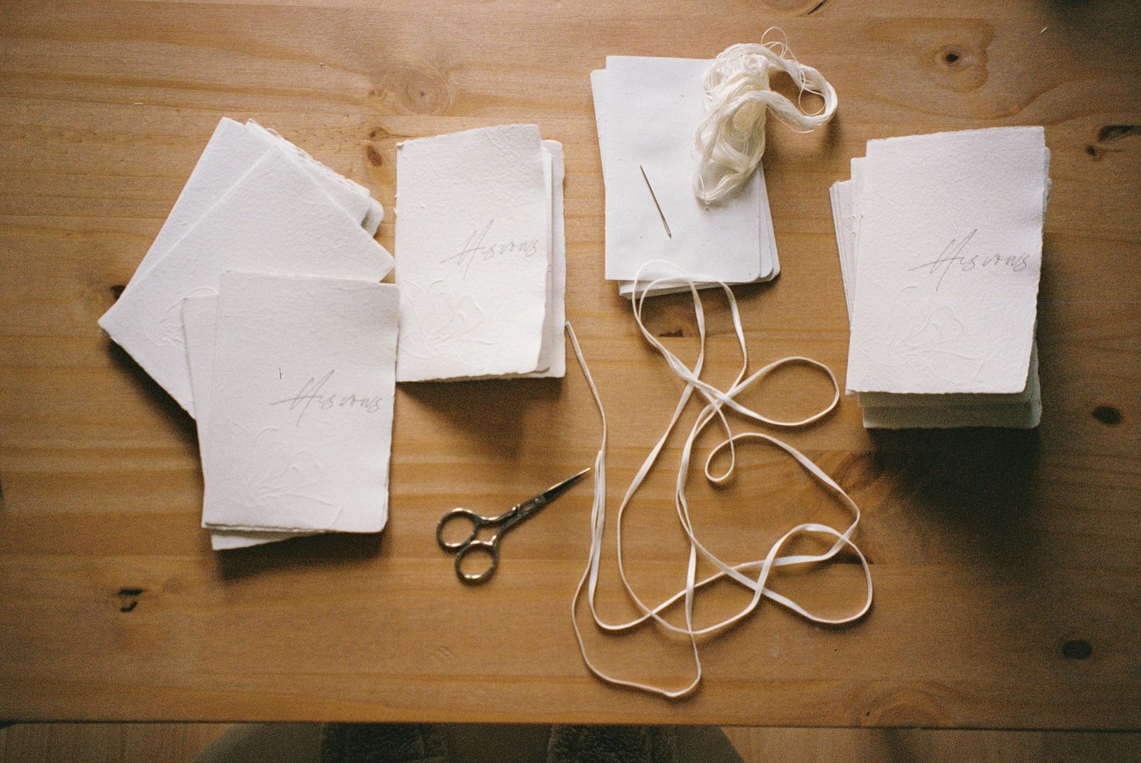 Paper cards, twine, and scissors on a wooden table