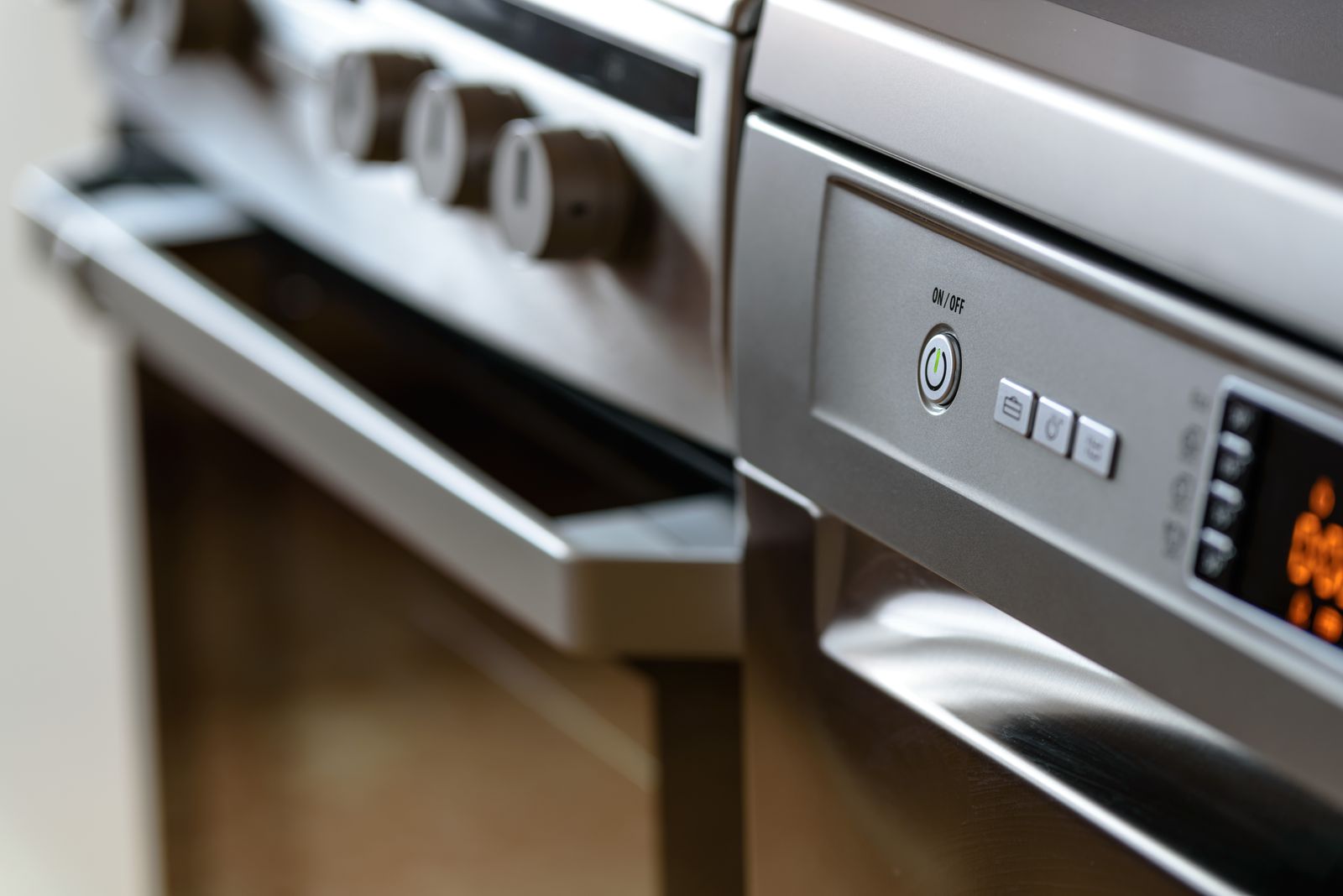 A closed dishwasher beside other kitchen cabinetry