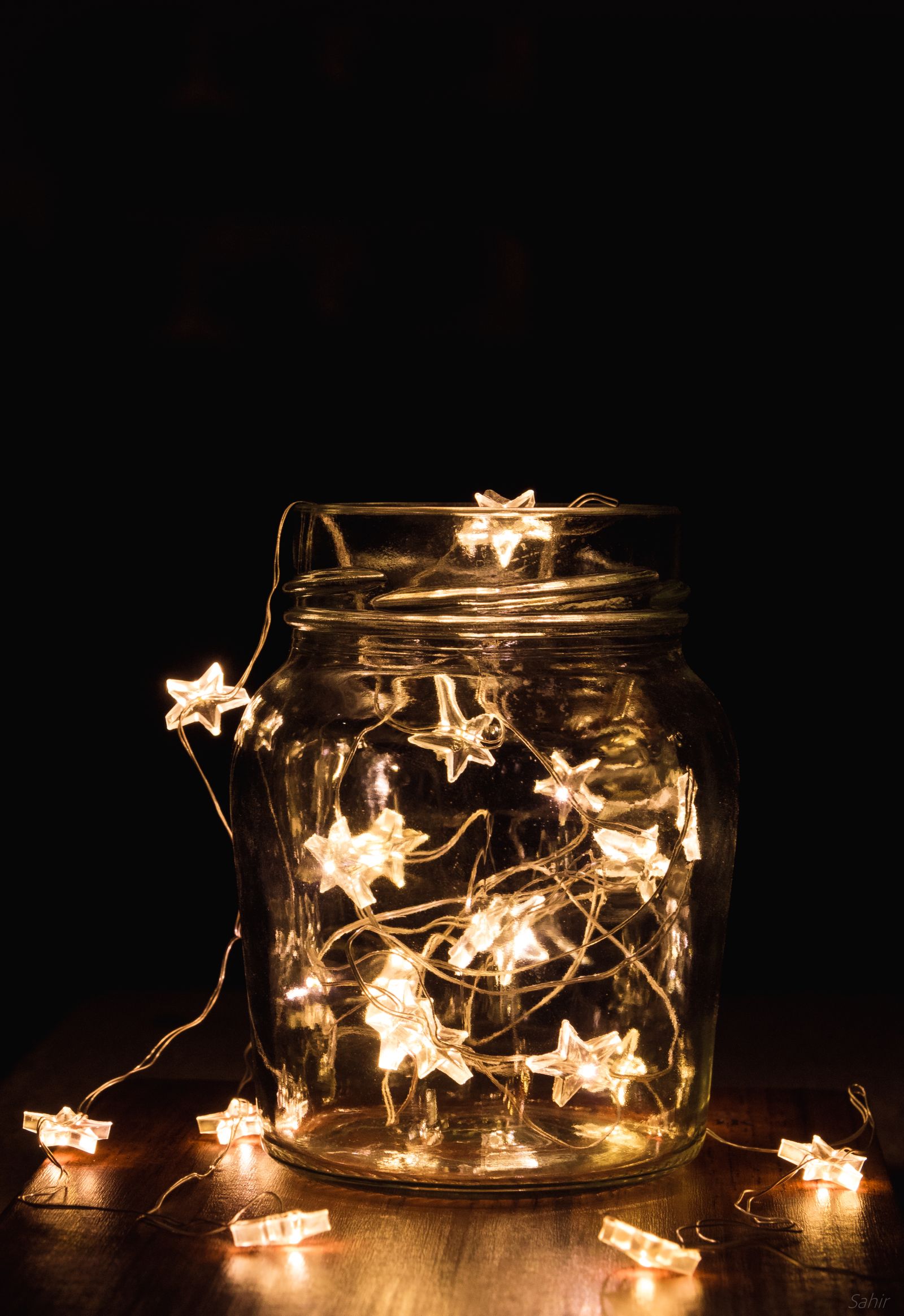 Star-shaped string lights glowing in a glass jar