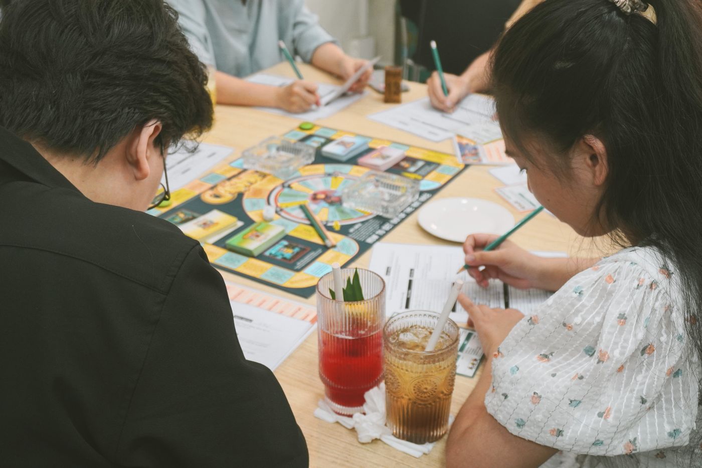Players checking a board game together at a table