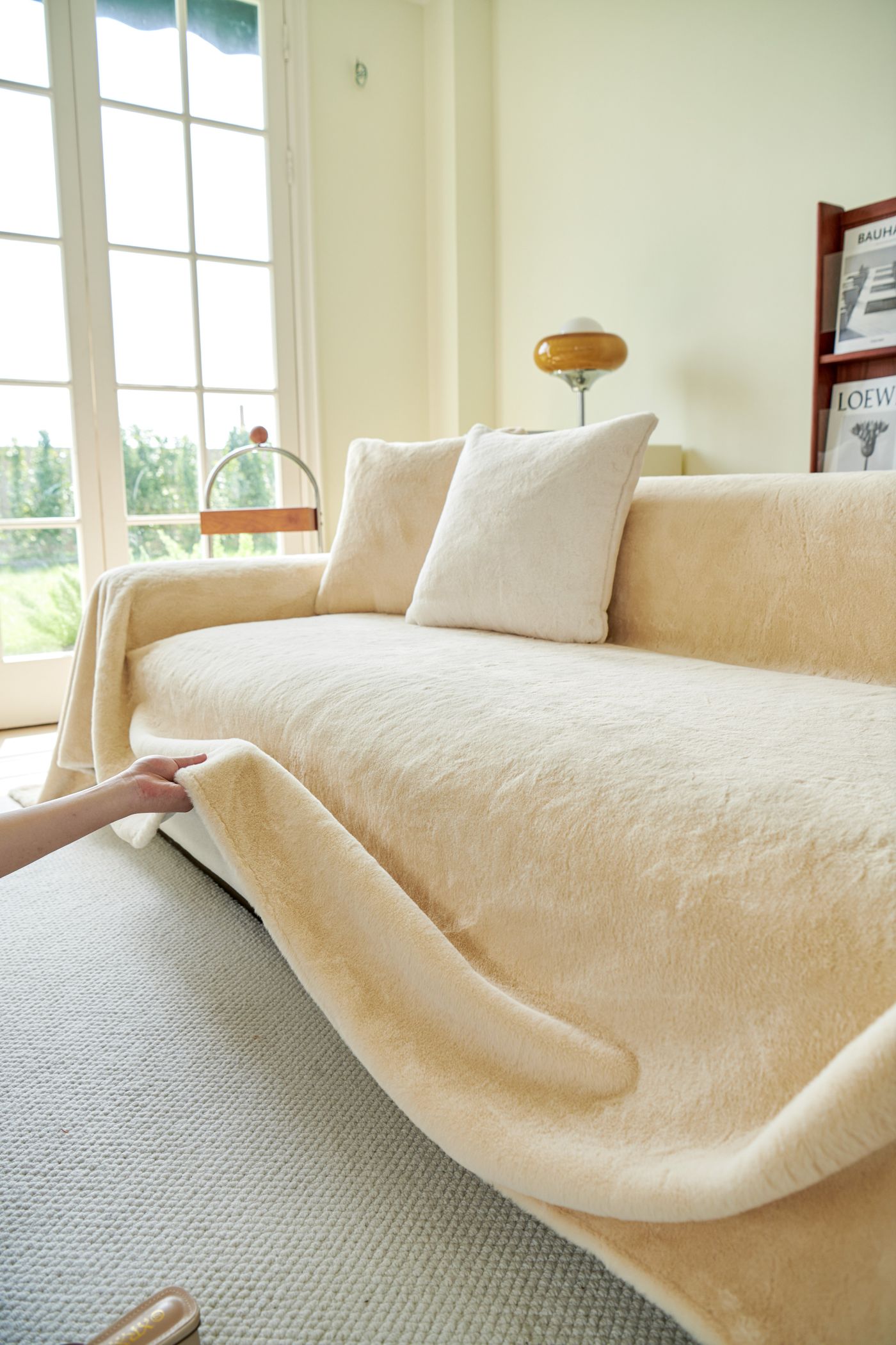 Cream furniture cover draped over a sofa seat and arm