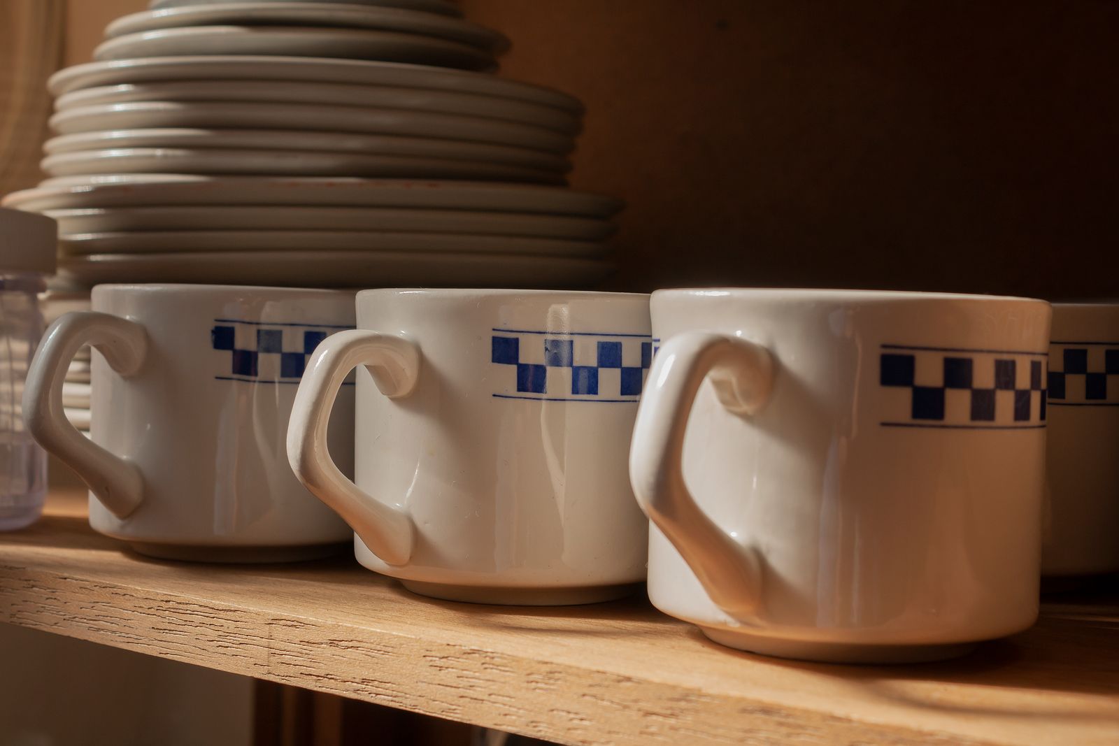 Coffee mugs arranged on a wooden kitchen shelf