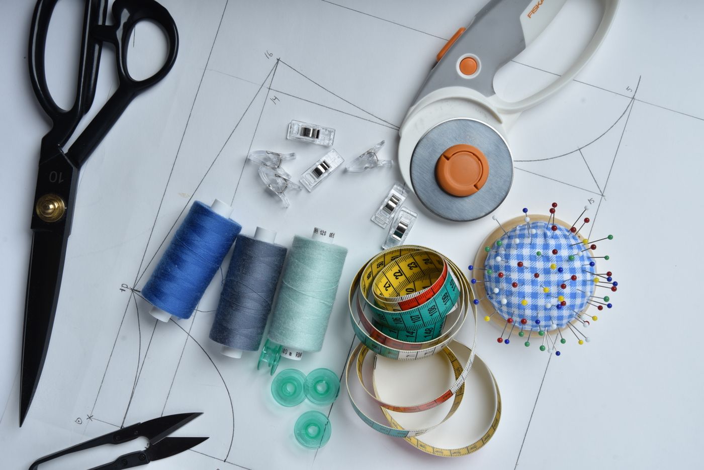 Sewing tools and thread grouped on a flat surface