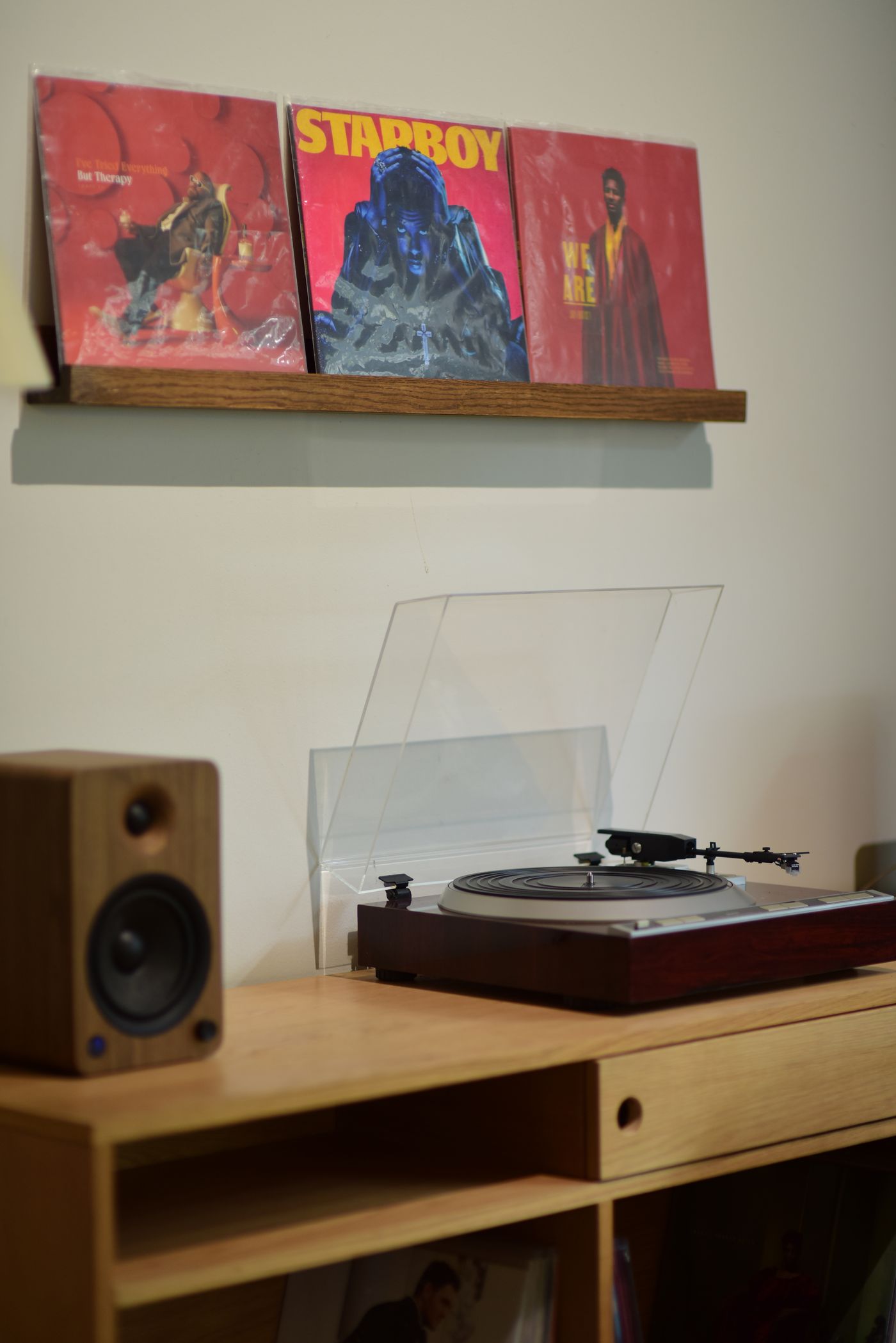 Turntable and album-cover shelf in a home; contextual listening-corner photograph, not a YINMIT product