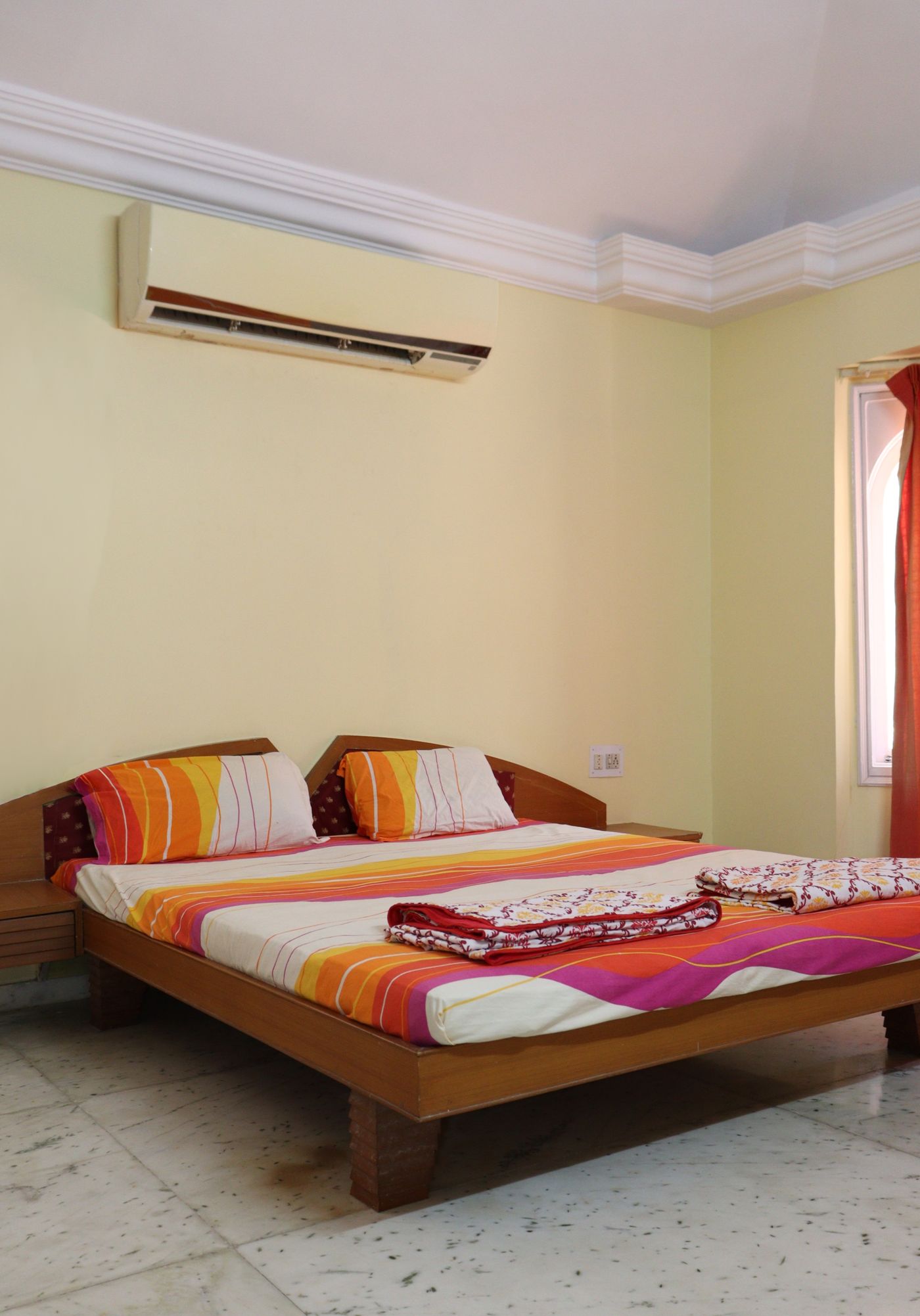 Small bedroom with warm-colored striped bedding