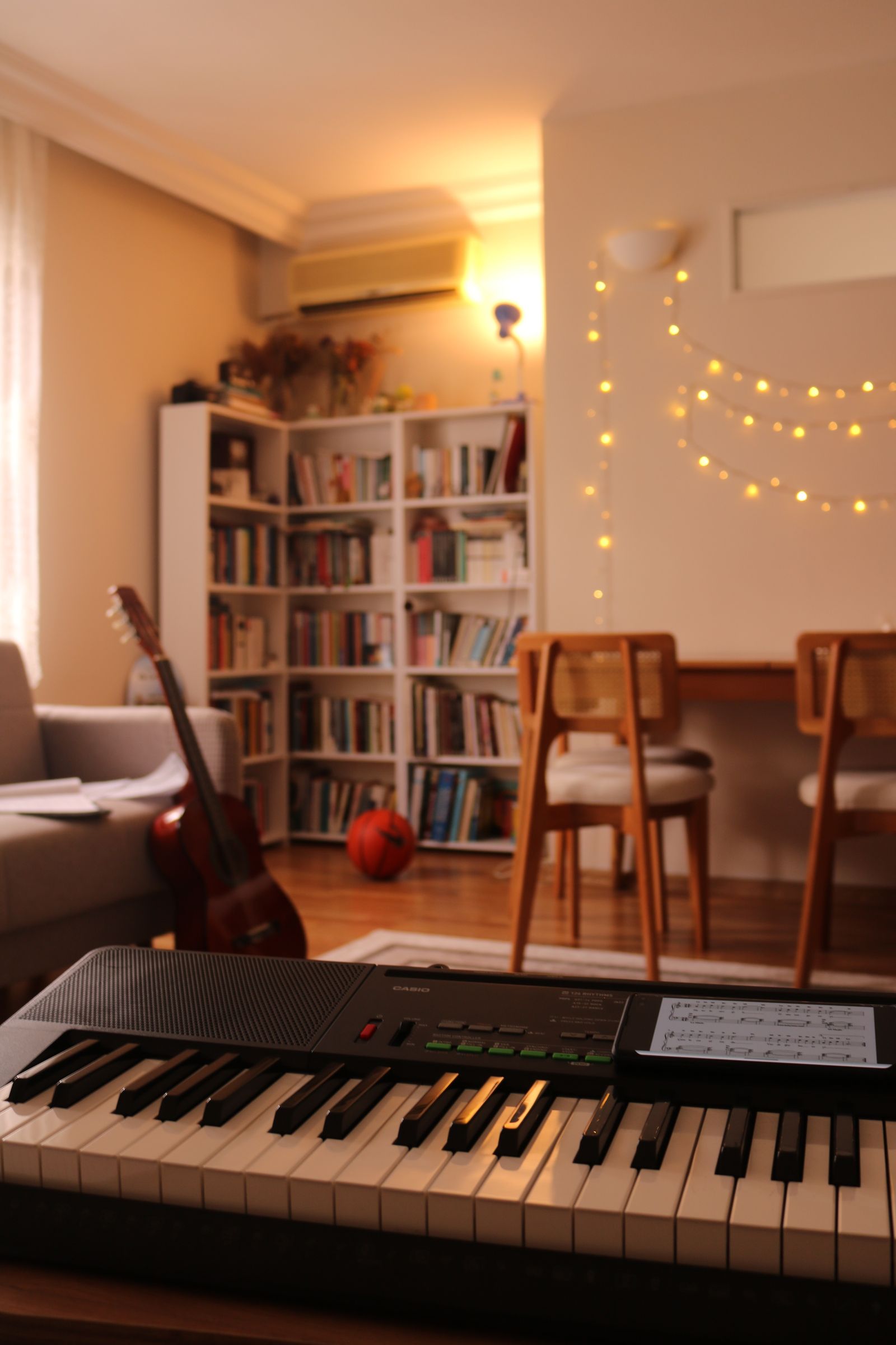 A keyboard in the foreground of a room with bookshelves