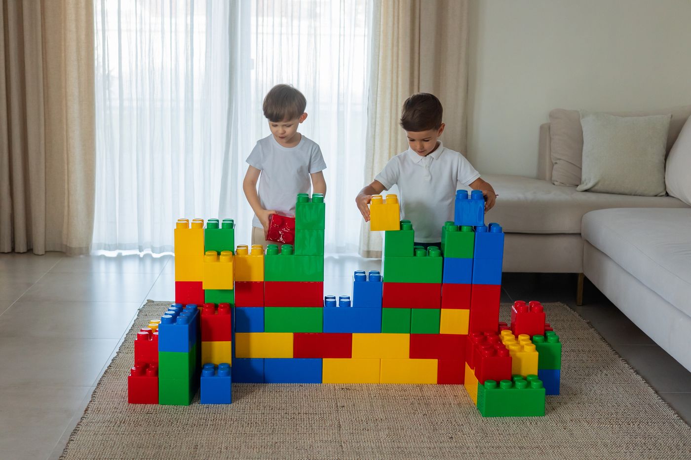 Children working with a large block structure in a room