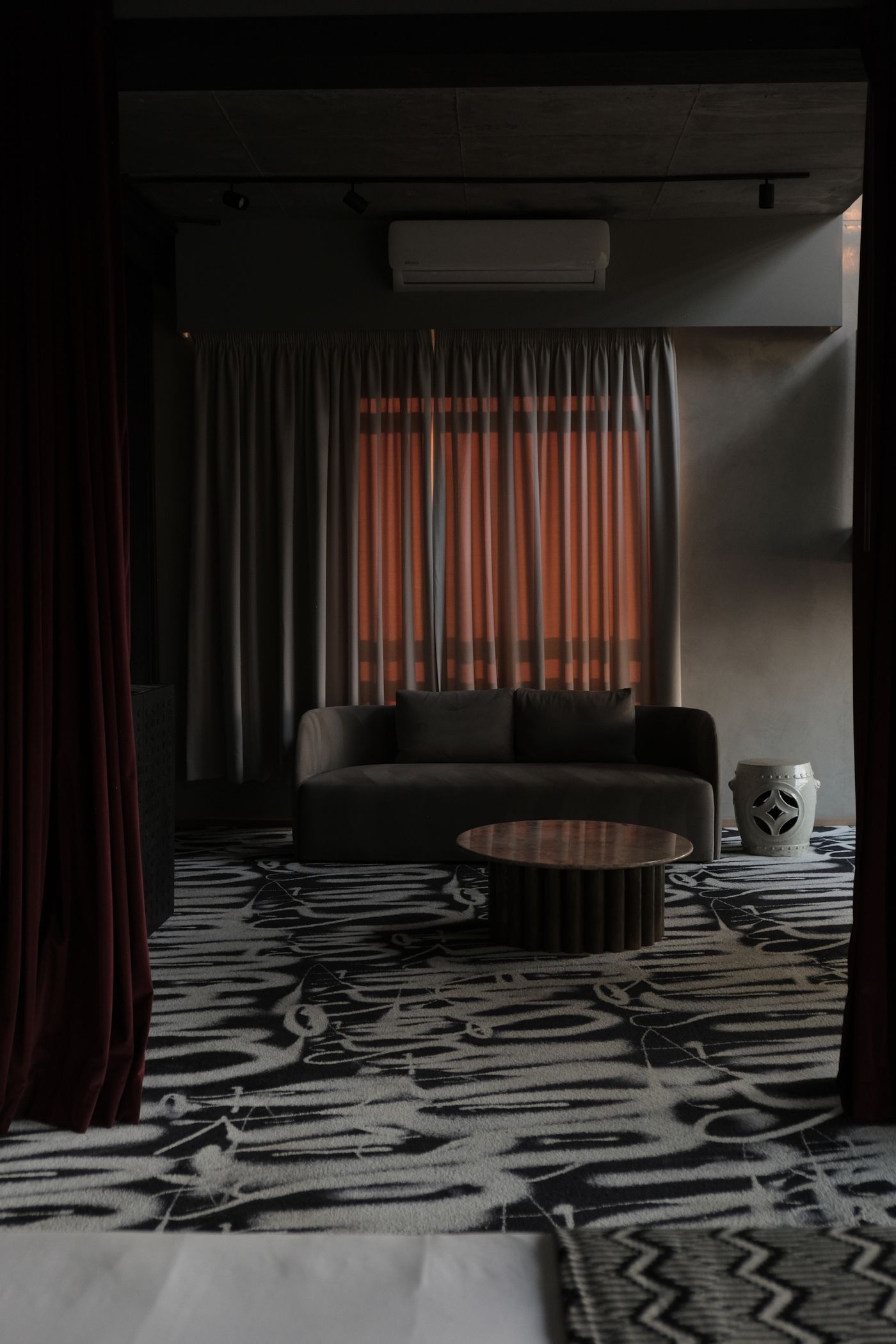 Strong rug pattern and striped curtains in a dark living room