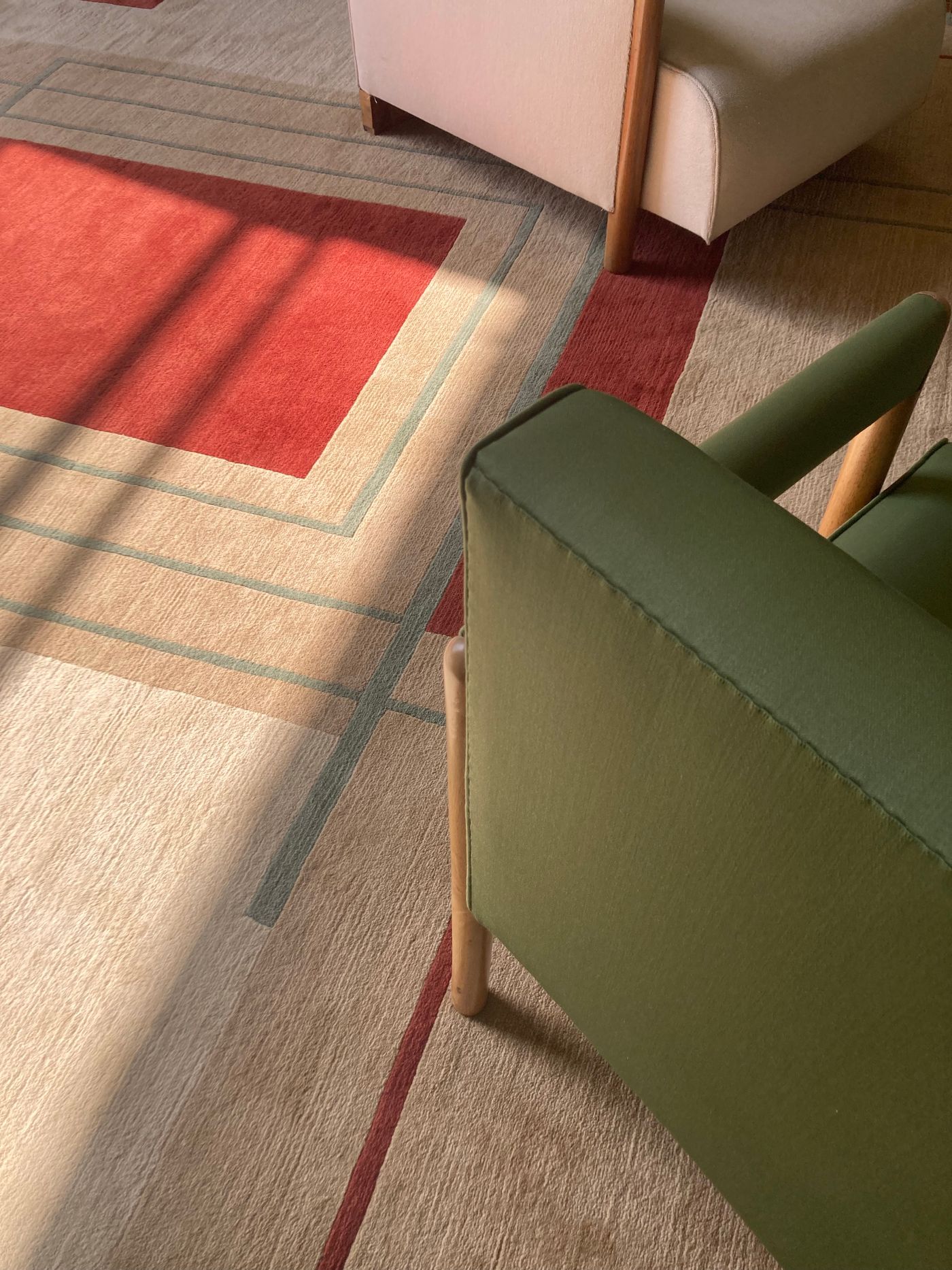 A close view of chair and sofa edges beside a patterned rug