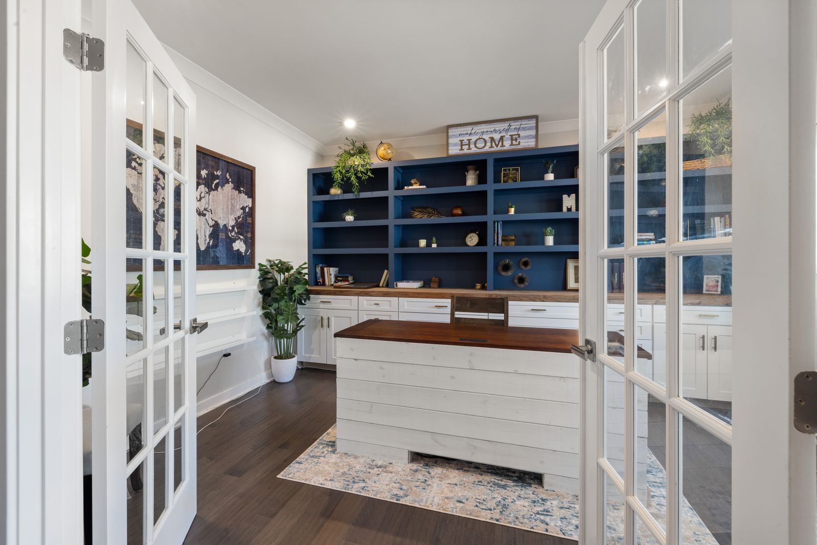 Home office with a white desk and blue shelving