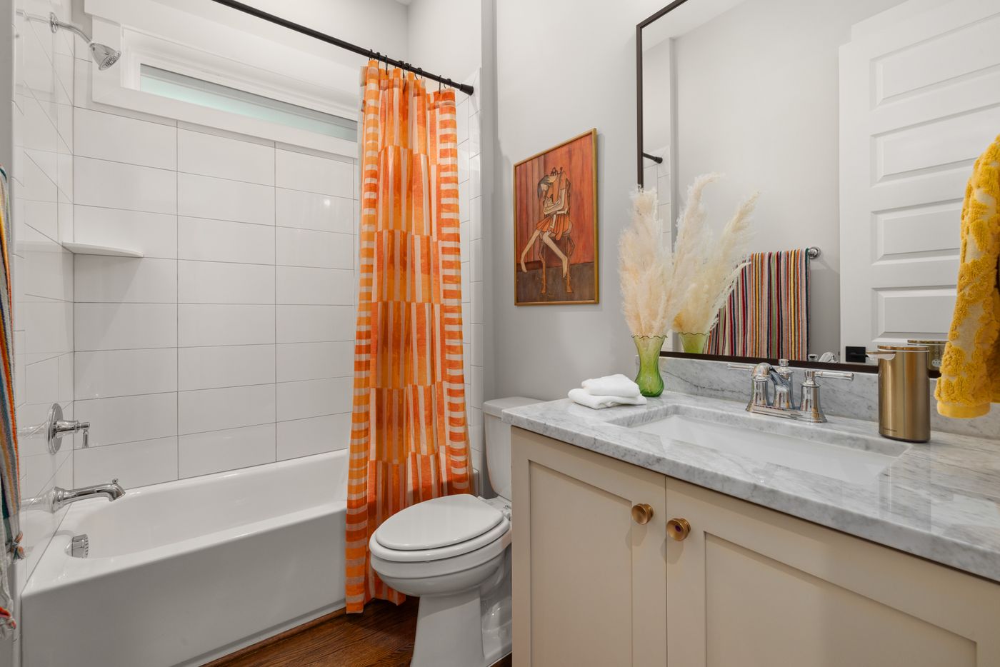Orange checked shower curtain beside bathroom fixtures