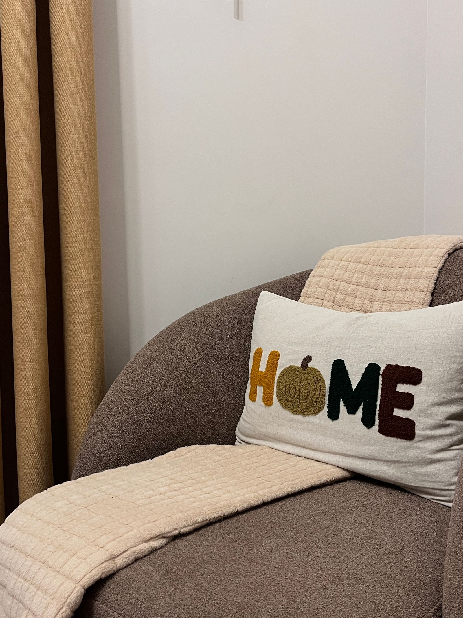 Autumn-themed cushion on a modern upholstered chair