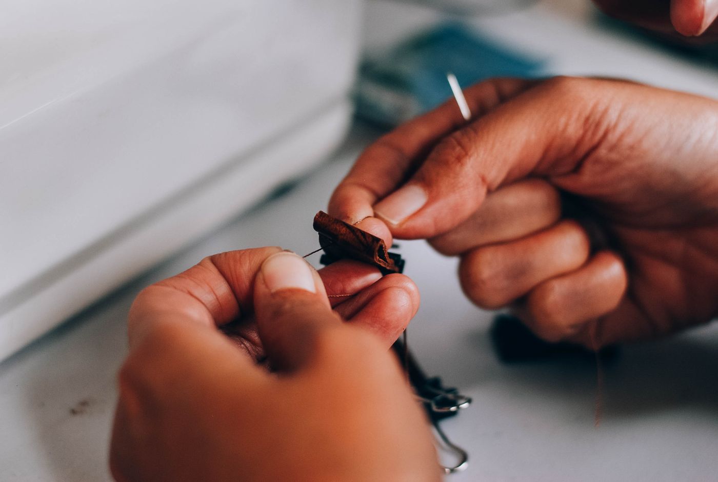 Hands holding a small dark sewing project