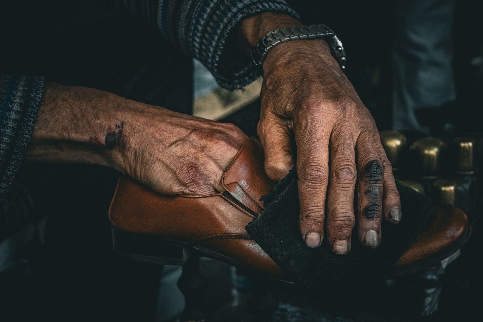 Hands polishing a dark shoe