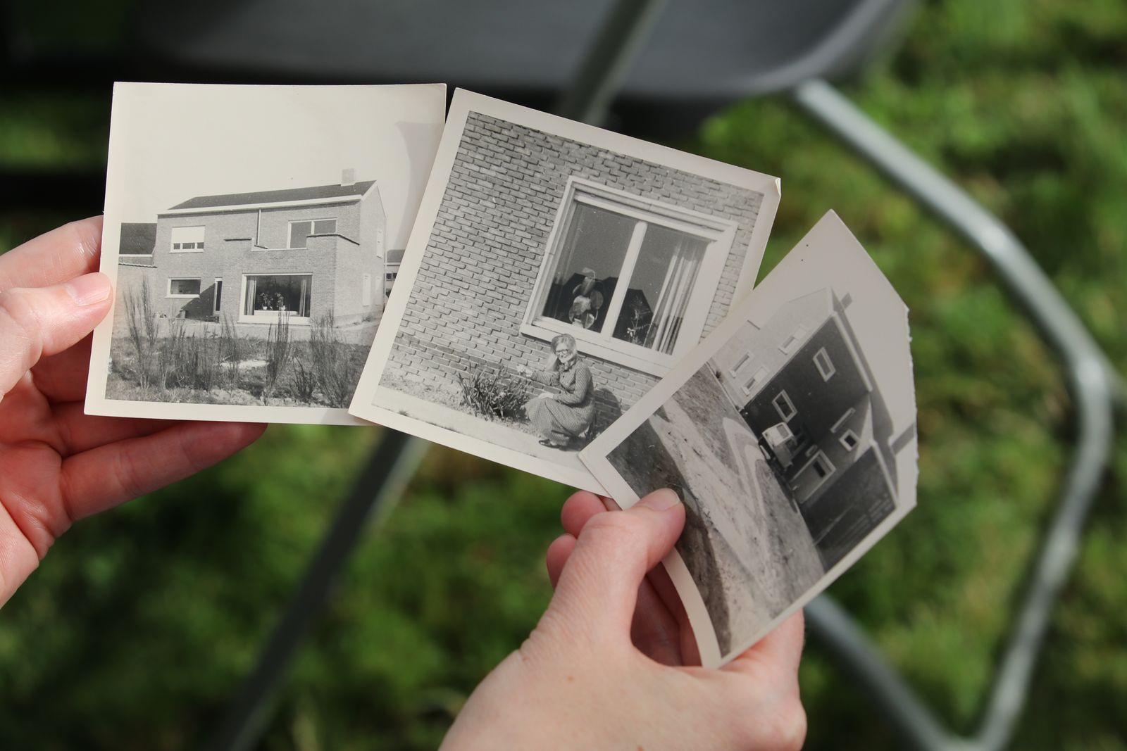 Hands holding an old newspaper with printed photographs