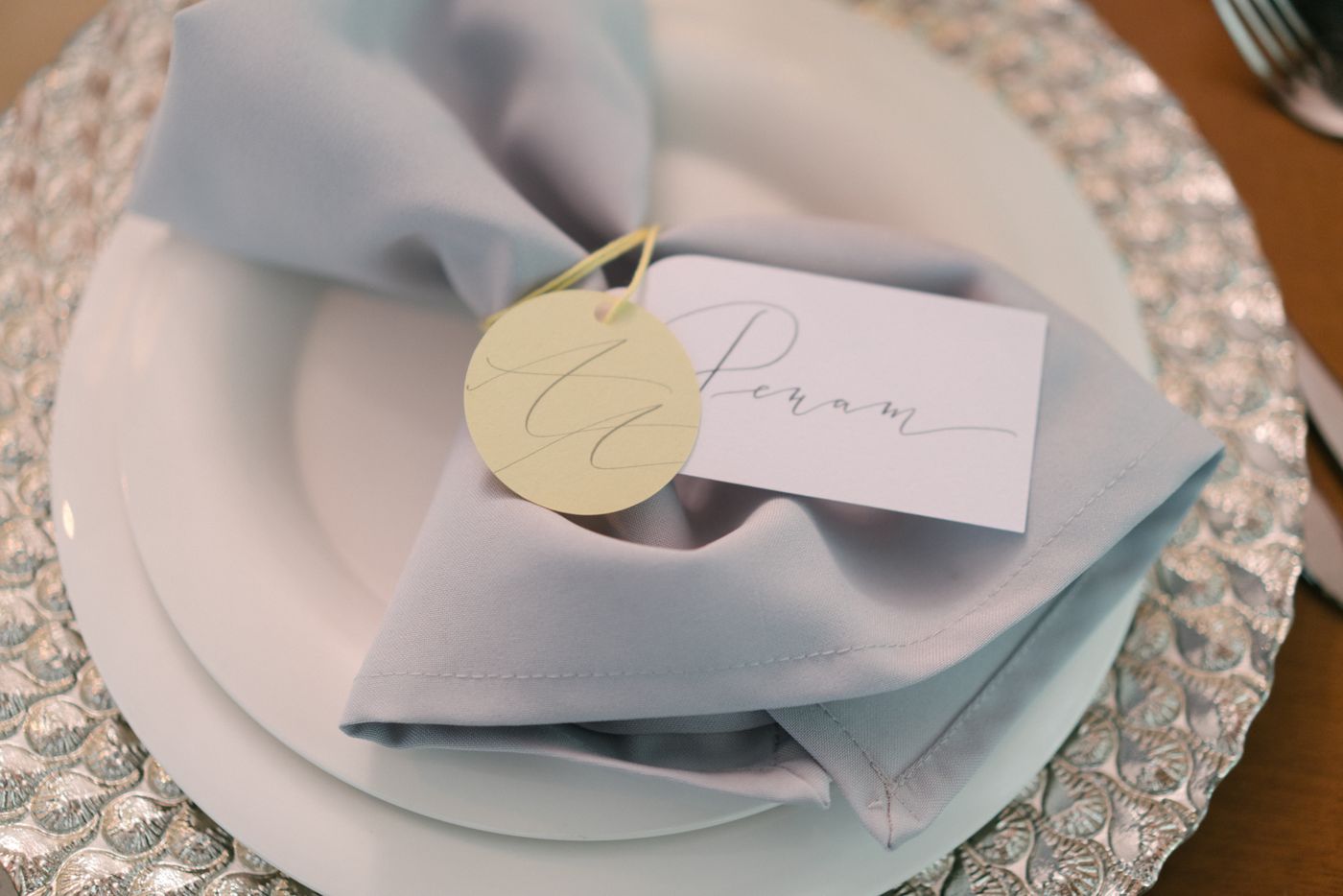 A handwritten place card resting on a folded napkin