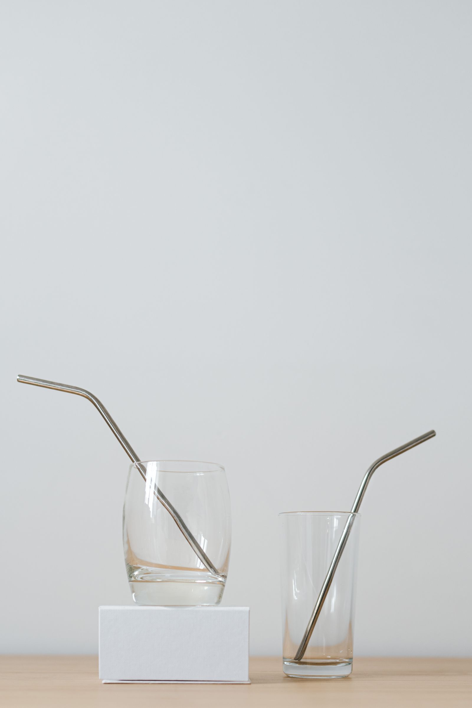 Two glasses containing bent metal drinking straws