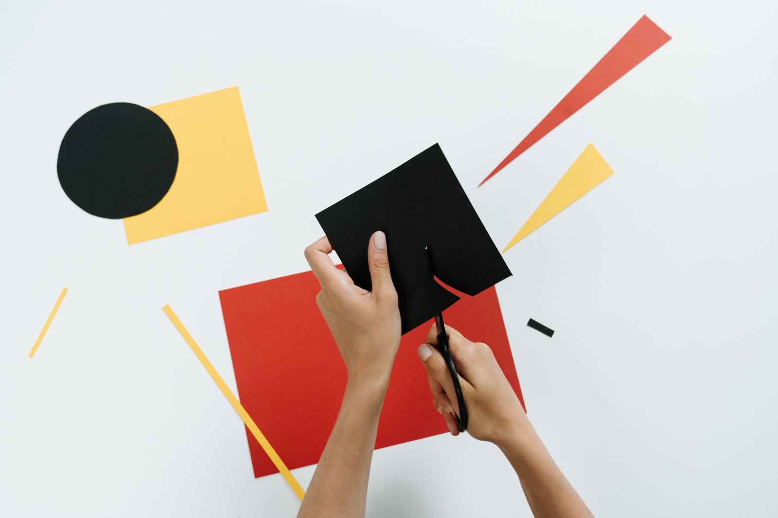 Hands working with colorful paper shapes