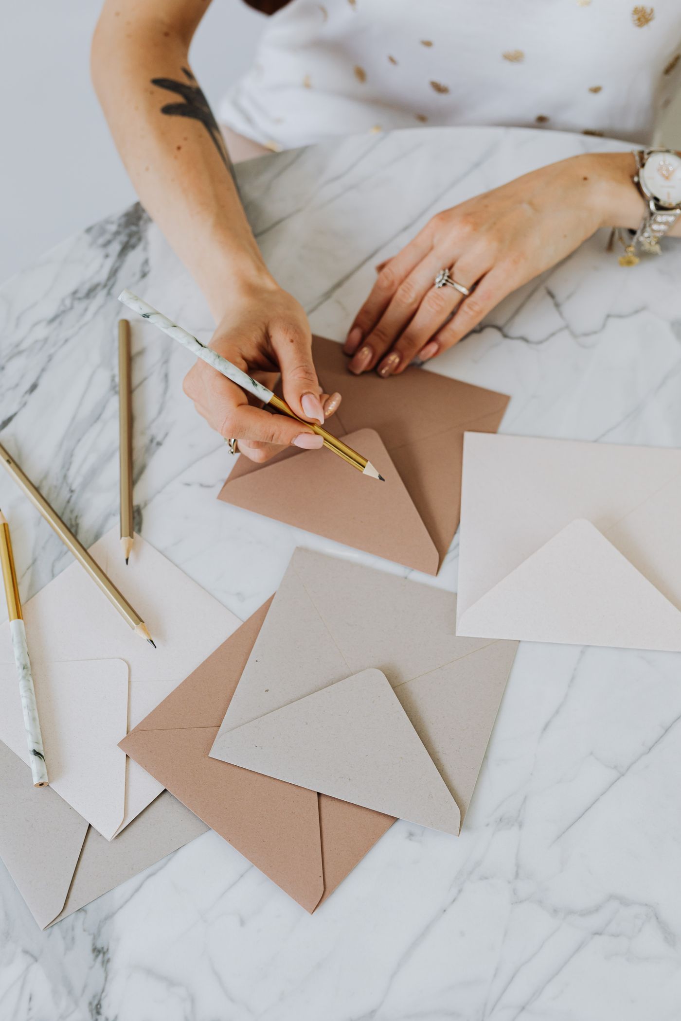 Hands writing on a card beside a matching envelope
