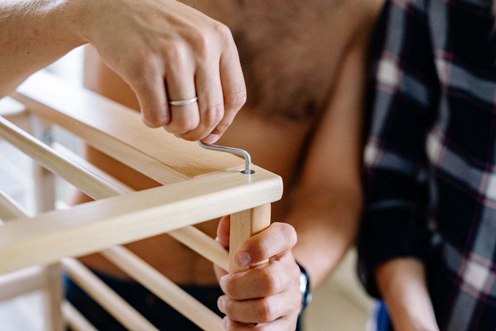 Hands fastening part of wooden furniture during assembly