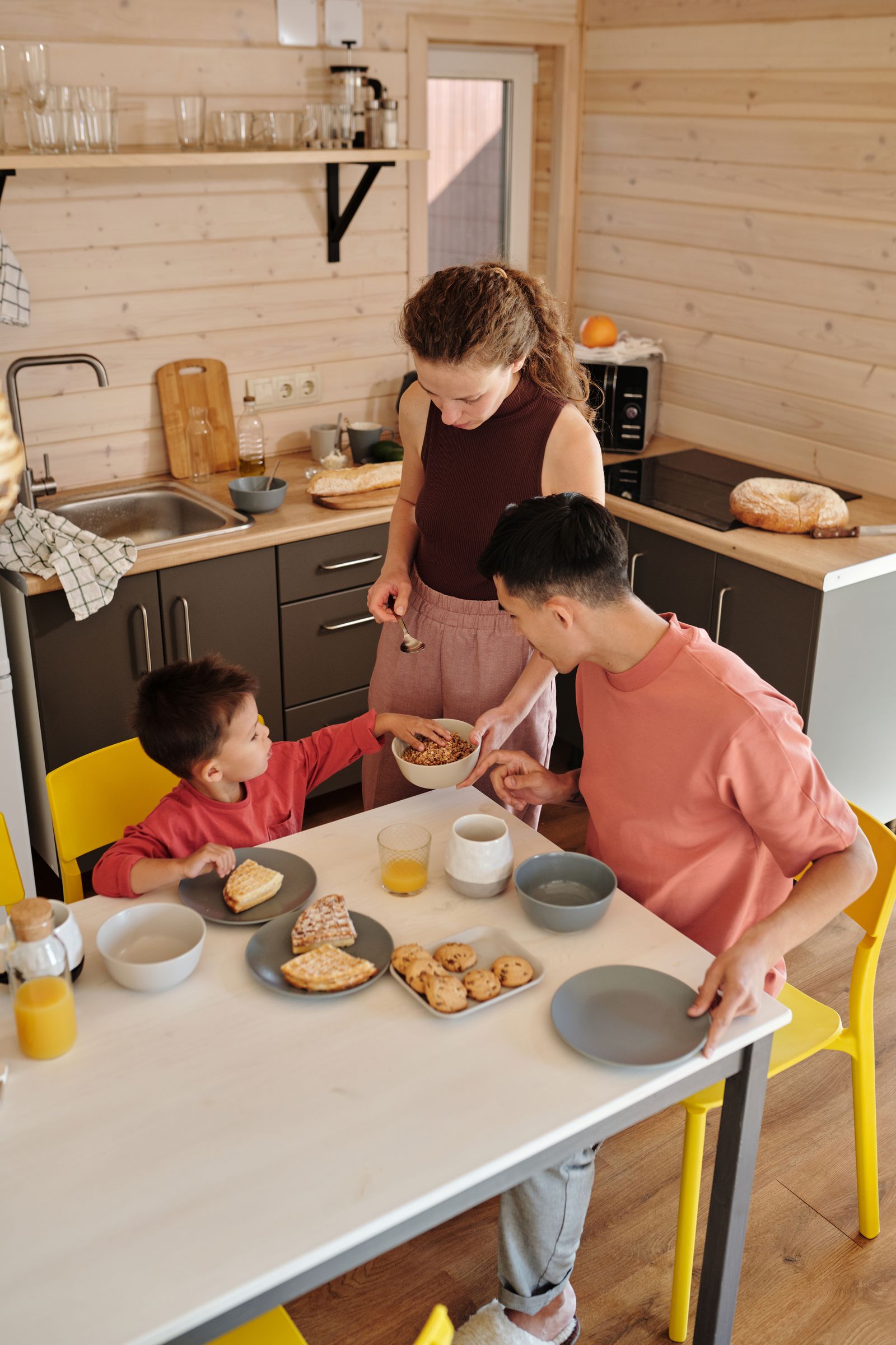 Adults and a child eating in a compact kitchen