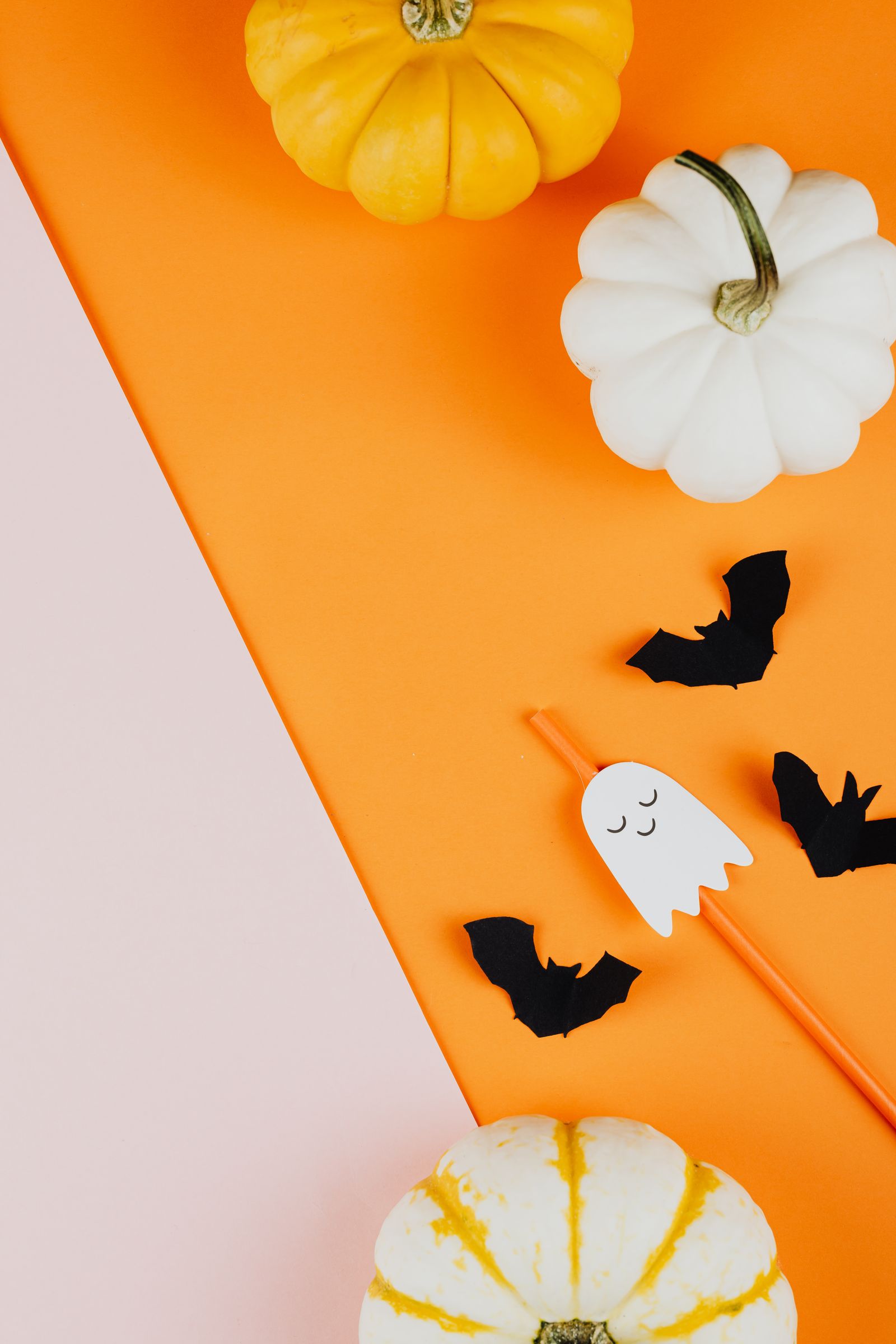 Pumpkins, a ghost-shaped straw, and bats on bright surfaces
