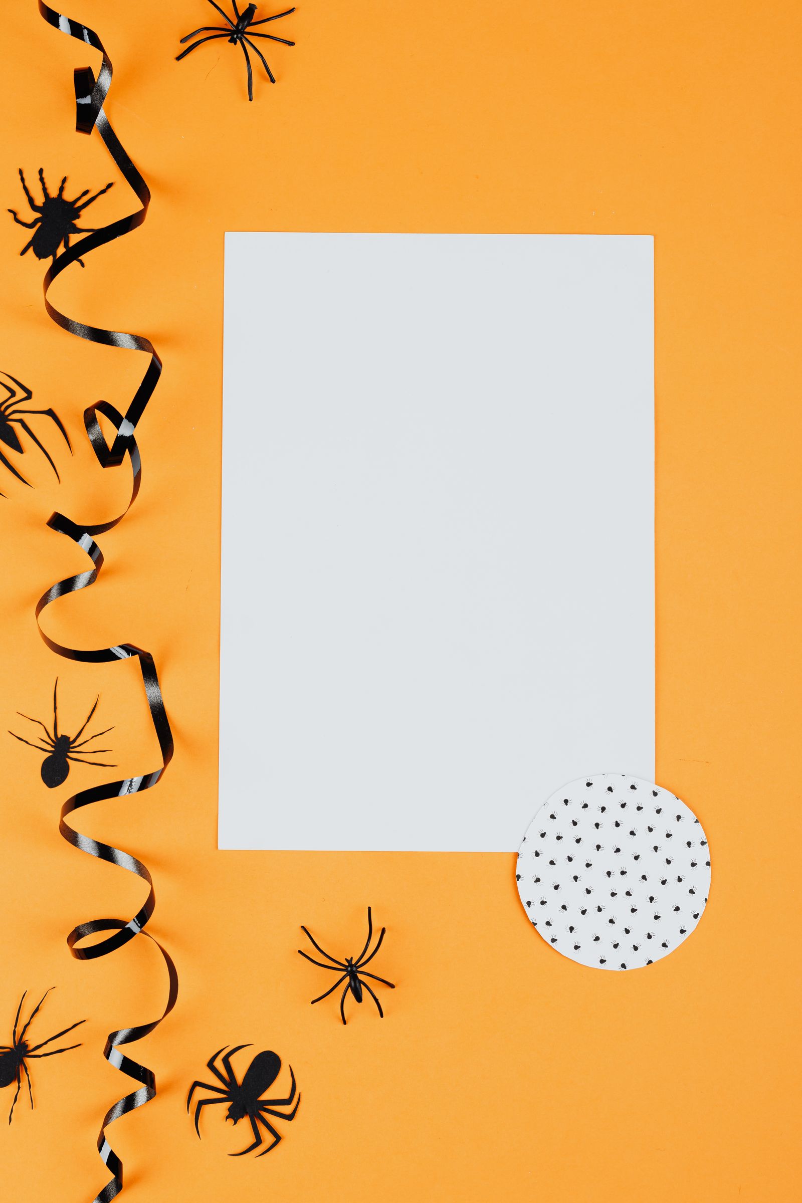 Paper spider decorations on an orange background